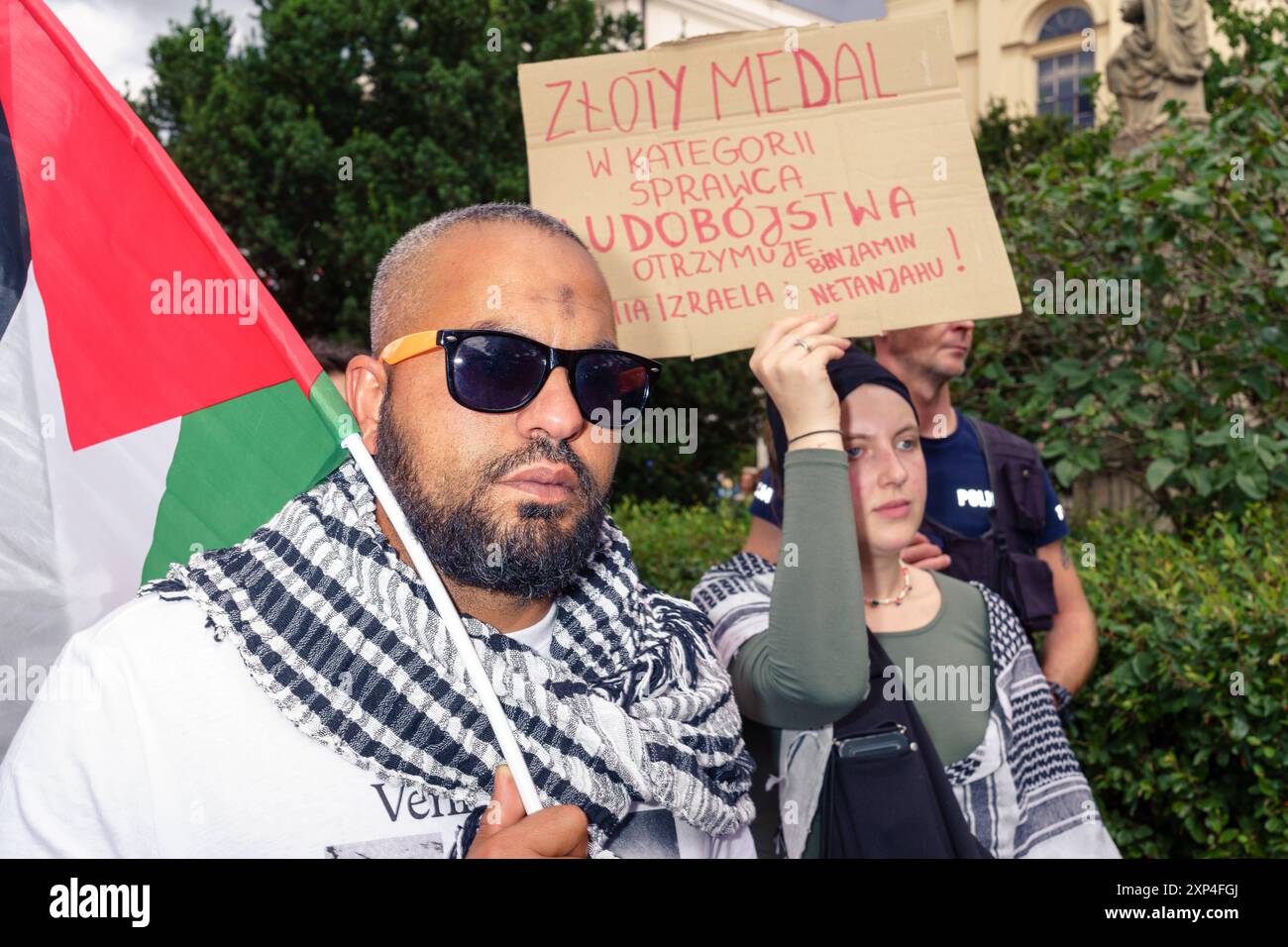 300 jours de génocide, protestation pour la défense de Gaza. Homme avec drapeau palestinien, bannière en arrière-plan médaille d'or dans la catégorie génocide est décerné à l'armée israélienne et Benjamin Nataniahu. Varsovie Pologne Copyright : xMikolajxJaneczekx Banque D'Images