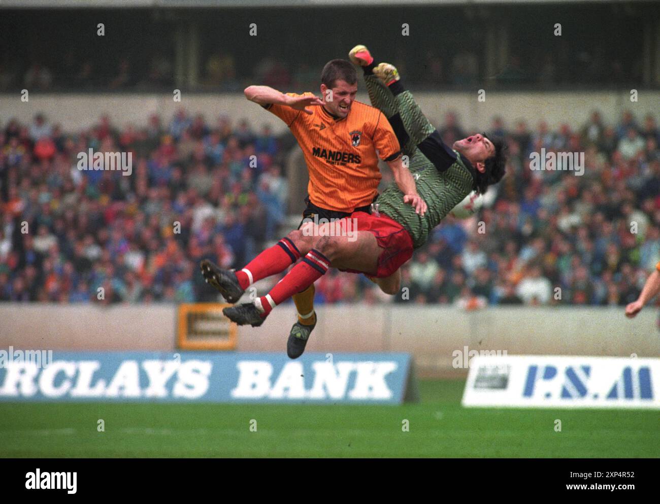 Wolverhampton Wanderers v Oxford United at Molineux 21/4/90 Steve Bull style Kung-fu s'écrase sur Alan Judge le gardien d'Oxford. Banque D'Images