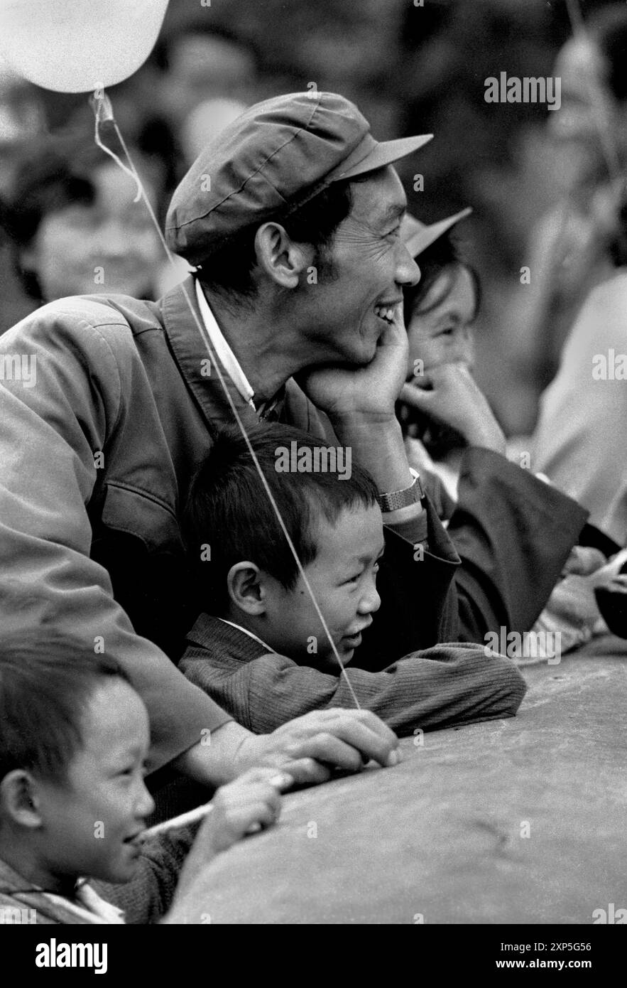 Père avec ses enfants lors de la Journée de la Nation à Kunming en Chine avant la révolution économique - 1986 Banque D'Images