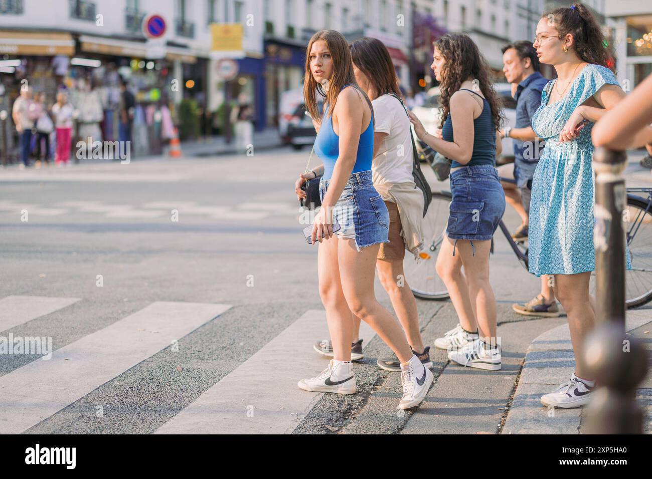 PARIS, FRANCE, 23.7,2024. Groupe de jeunes femmes traversant la route devant l'attraction moulin rouge à Paris..cadre estival Banque D'Images