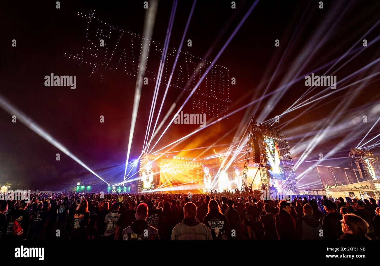 Wacken, Allemagne. 03 août 2024. Le logo du groupe 'Saltatio Mortis' est projeté au-dessus des scènes lors d'un spectacle de drone à la fin du Wacken Open Air. Le WOA est considéré comme le plus grand festival de heavy metal au monde. Crédit : Axel Heimken/dpa/Alamy Live News Banque D'Images