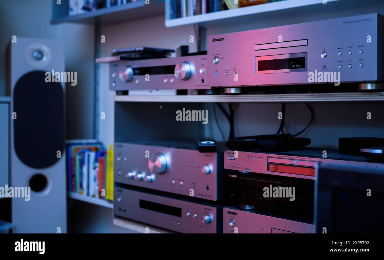 Paris, France - 1er août 2024 : étagères Vitsoe présentant plusieurs composants hi-fi Onkyo ainsi qu'un lecteur CD Super Audio Pioneer PD-50 AE et MQA de luxe, sur fond de teinte bleu magenta, mettant en valeur un équipement audio haut de gamme Banque D'Images