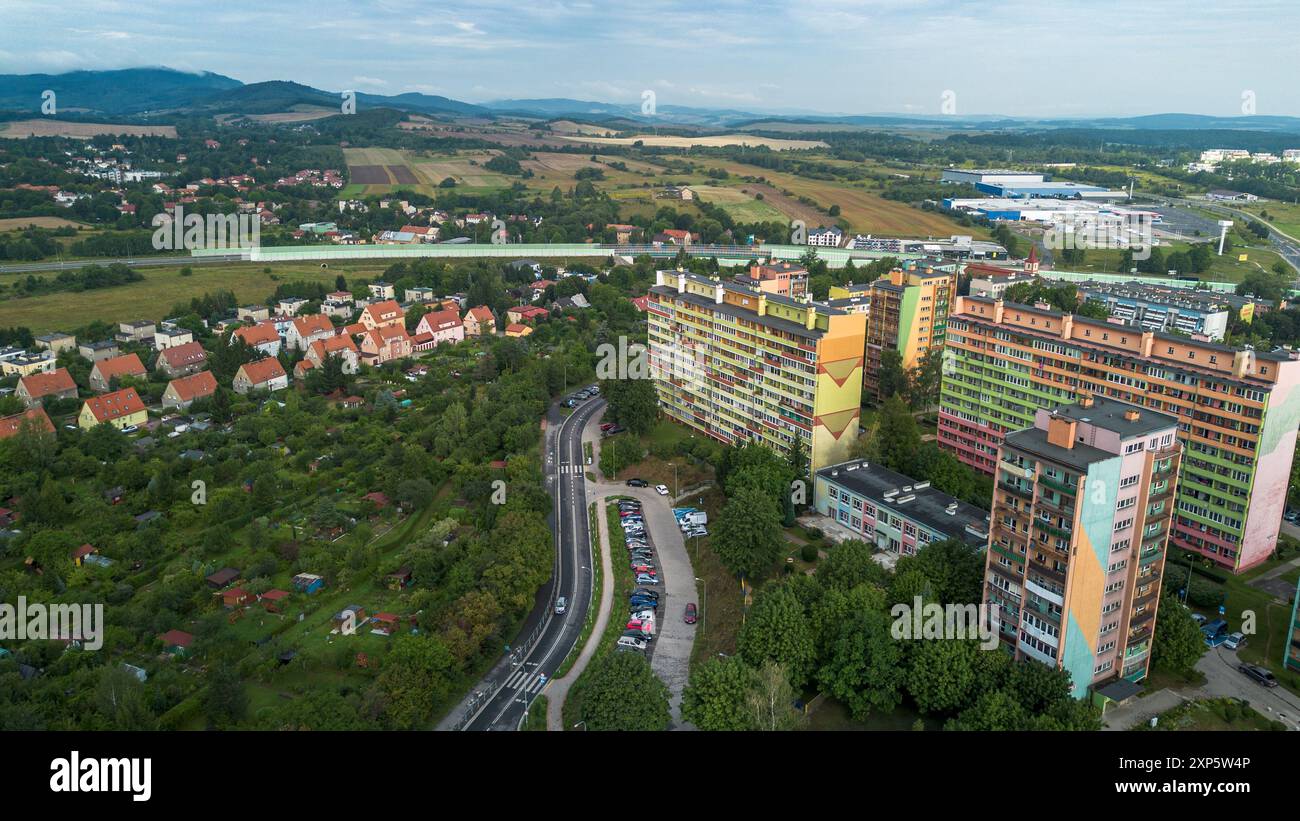 Vue aérienne du quartier résidentiel entouré de champs verts et de montagnes dans la lumière tôt le matin Banque D'Images