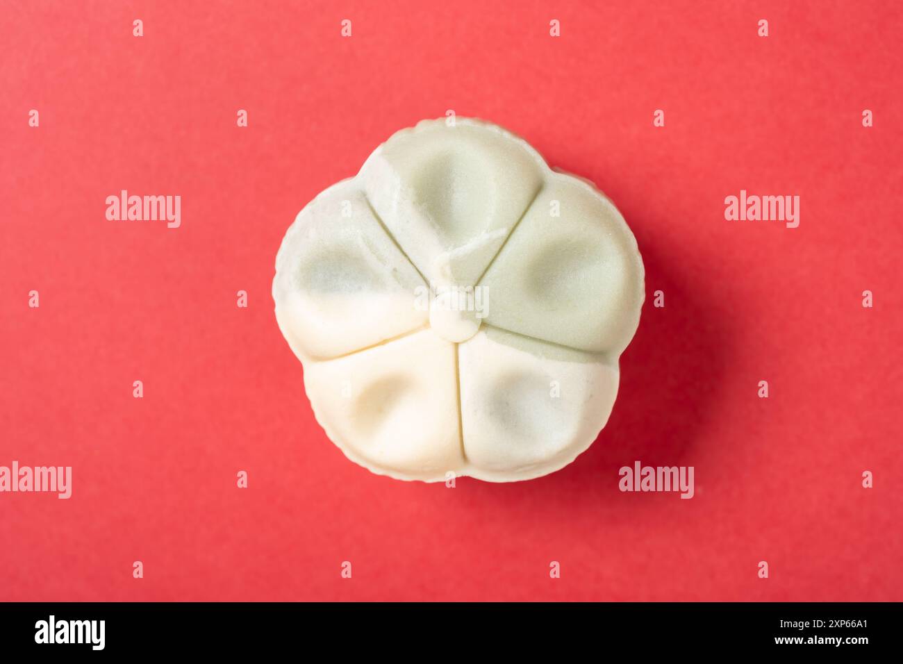 vue de dessus forme de fleur blanc et vert clair mooncake sur rouge Banque D'Images