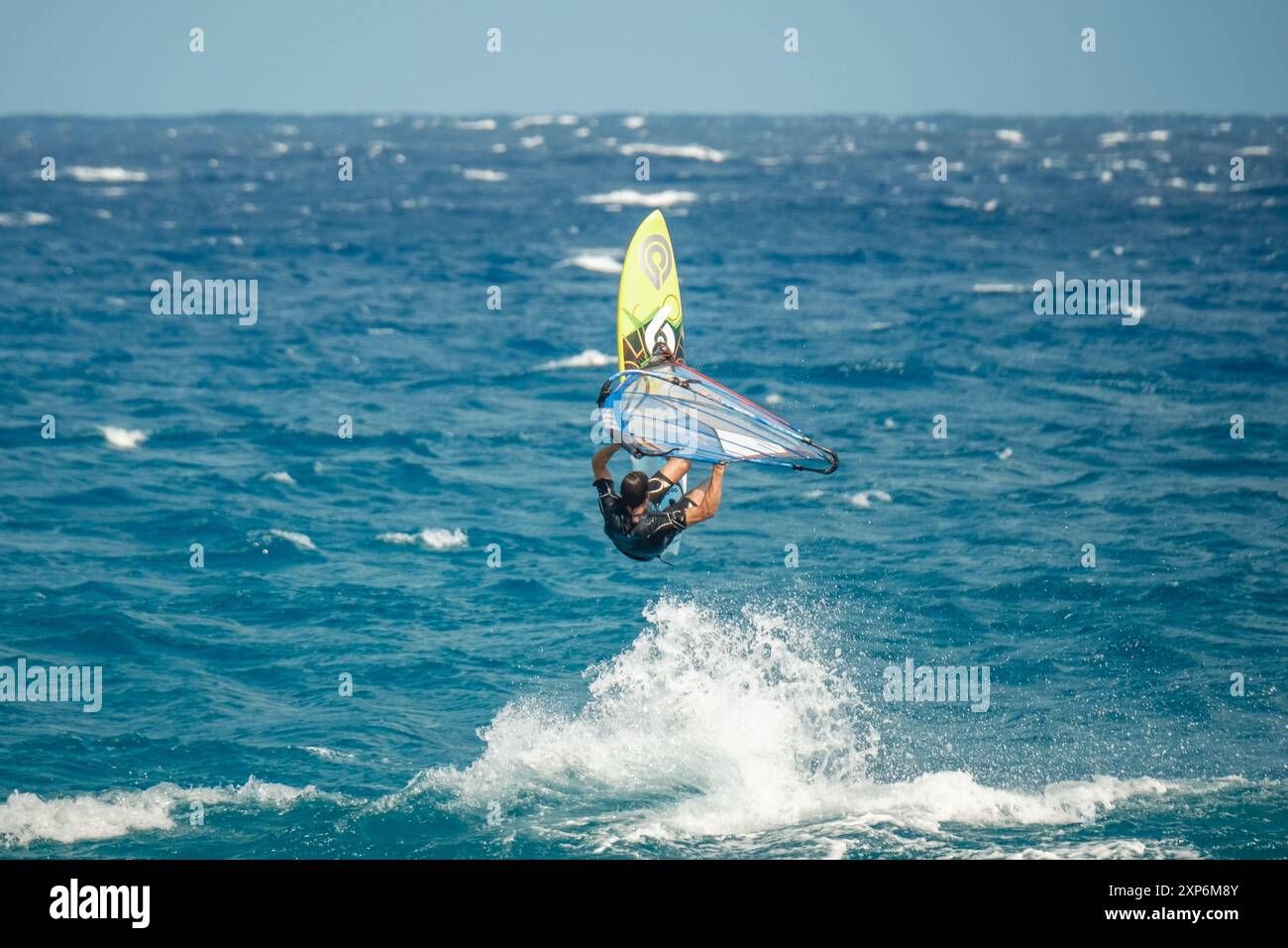Algajola, Corse, France - 31 mai 2024 : un windsurfeur prend les airs au-dessus de fortes vagues au large d'Aregno plage à Algajola sur la côte méditerranéenne Banque D'Images