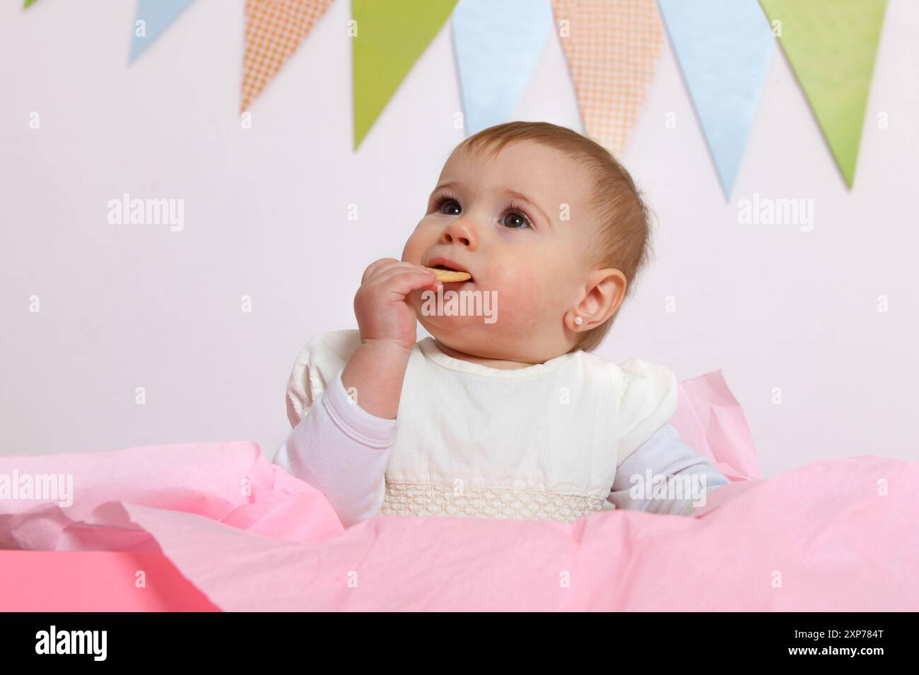 portrait d'une petite fille mignonne mangeant un cookie sur fond blanc Banque D'Images