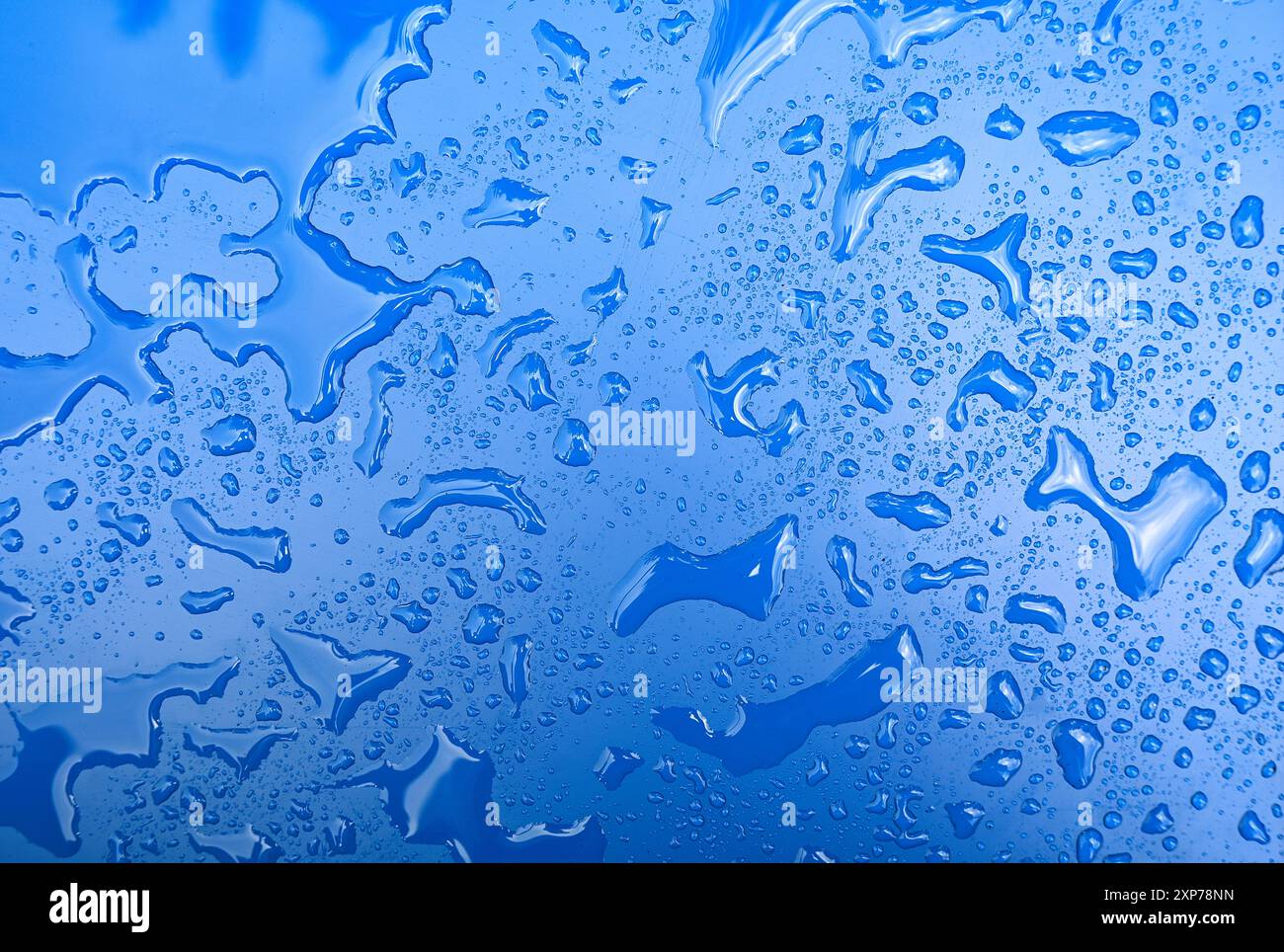 Formes abstraites de l'eau après la pluie sur la surface bleue comme texture ou fond Banque D'Images