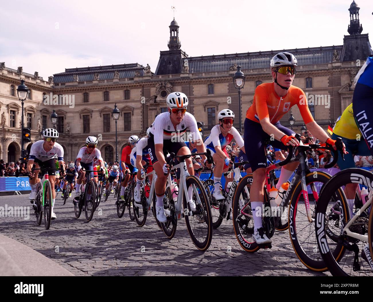 Le peloton passe devant le Musée du Louvre lors de la course cycliste féminine sur route, le neuvième jour des Jeux Olympiques de Paris 2024 en France. Date de la photo : dimanche 4 août 2024. Banque D'Images