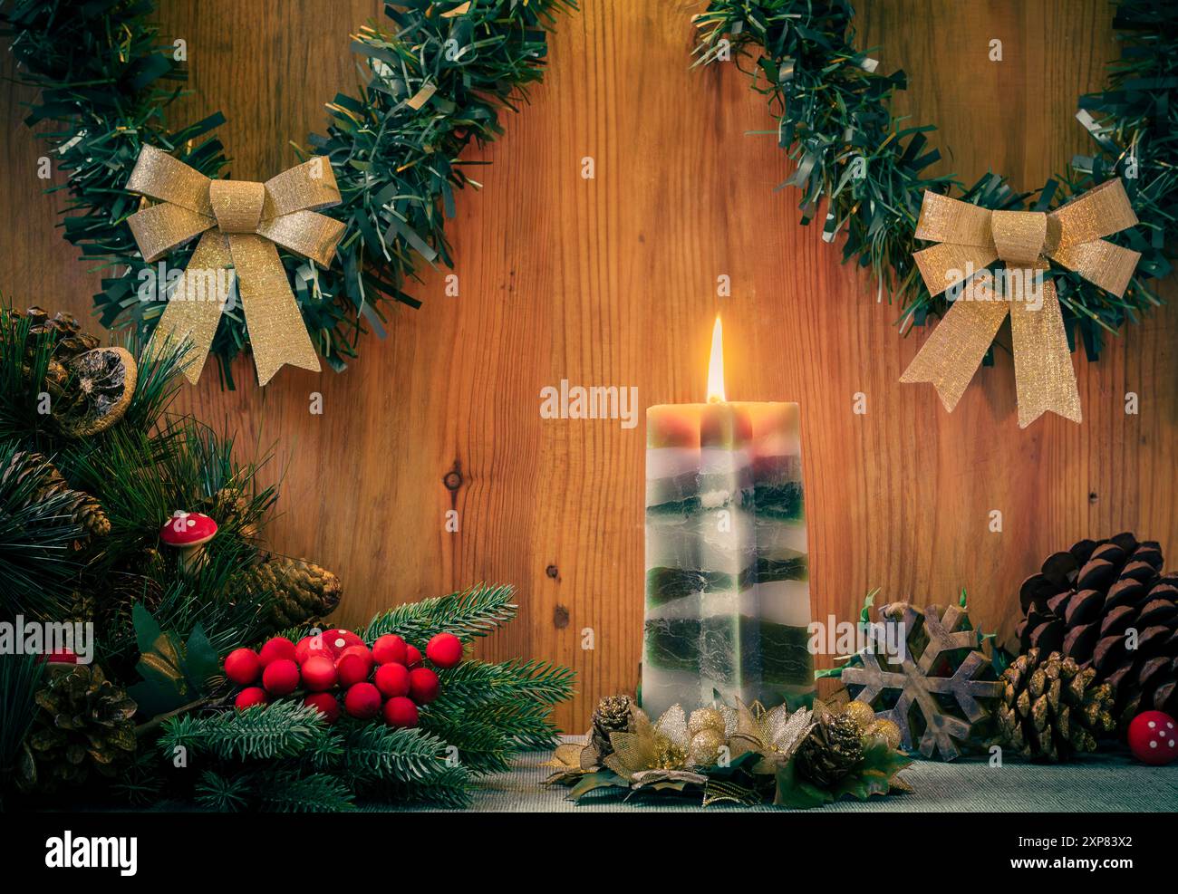 Bougie entourée de décorations traditionnelles de noël sur fond de bois Banque D'Images