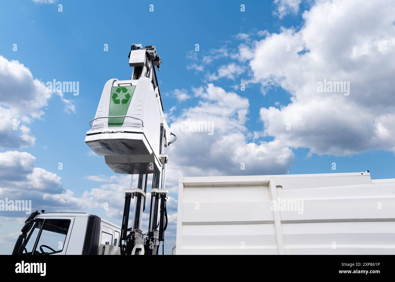 Le camion à ordures soulève la poubelle de rue pour les déchets recyclables. Banque D'Images