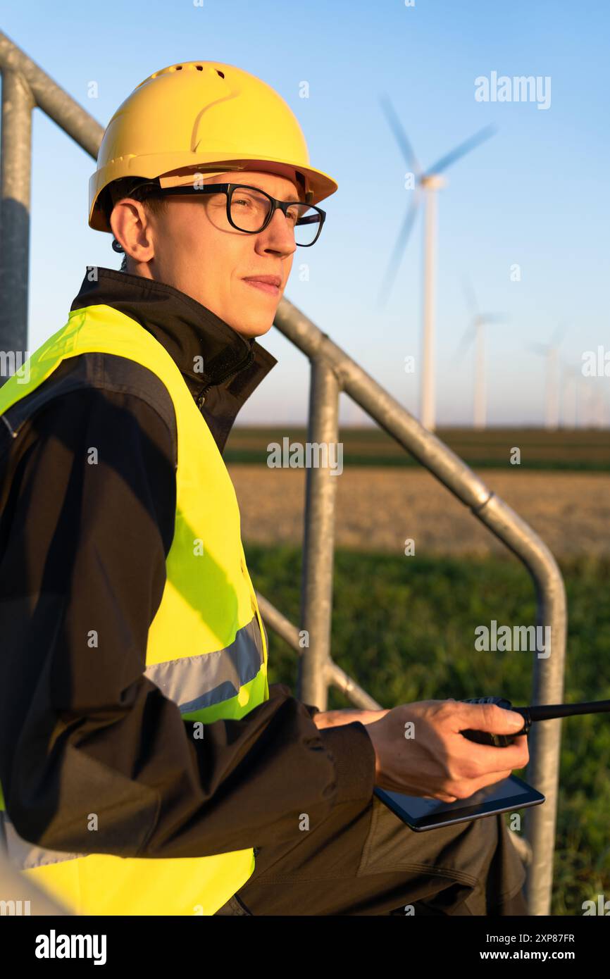 Ingénieur avec tablette numérique contrôle les éoliennes. Banque D'Images