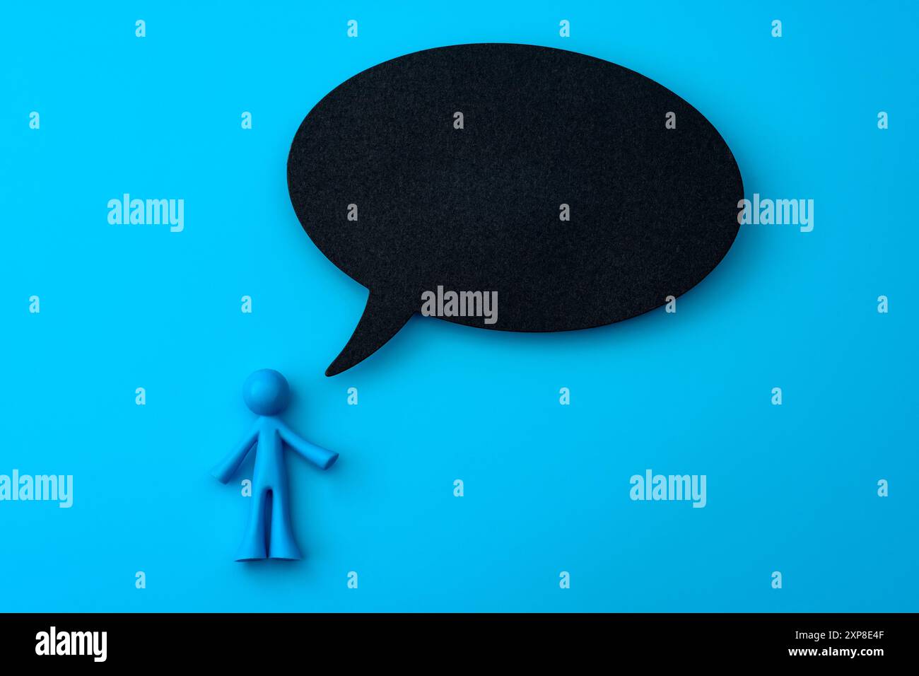 Figurine bleue avec concept Black Speech Bubble pour une conception de communication minimaliste, une expression visuelle dans les médias sociaux et une présentation graphique créative Banque D'Images