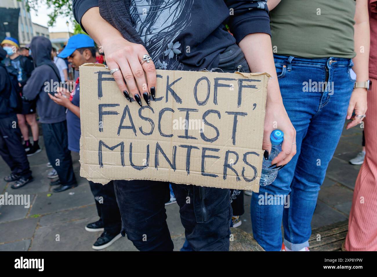 Riot de Bristol - un activiste anti-racisme portant un panneau anti-fasciste affronte des activistes d'extrême droite à Castle Park dans le centre de Bristol. 03-08-024 Banque D'Images