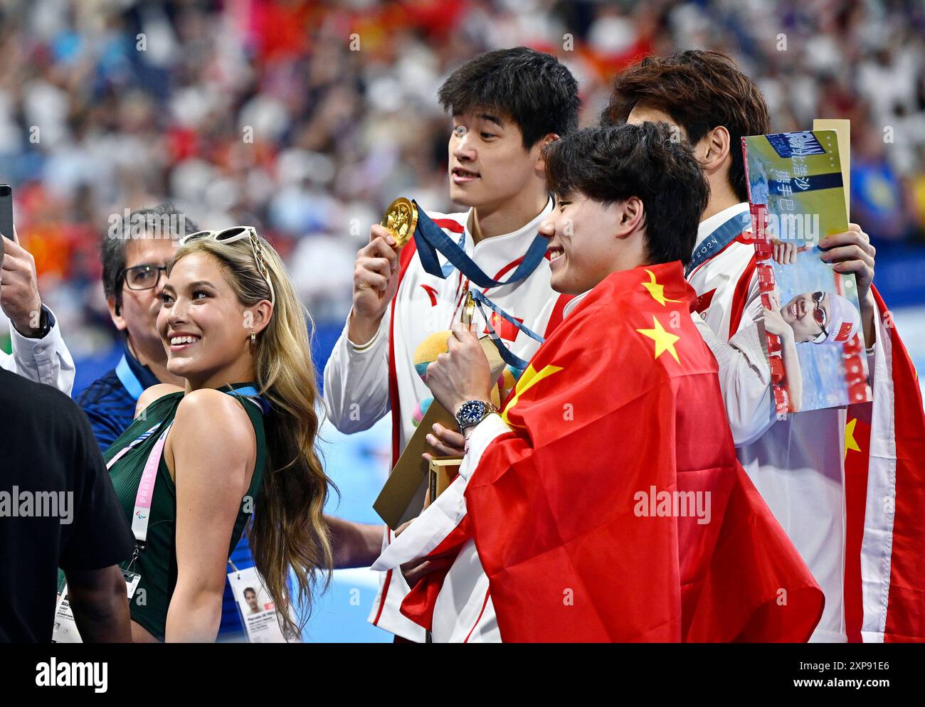 Paris, France. 4 août 2024. Le champion olympique d'hiver chinois Gu Aailing (1er l), également connu sous le nom d'Eileen Gu, pose avec les médaillés d'or Team China après la cérémonie de victoire pour le relais de natation 4 x 100 m masculin aux Jeux Olympiques de Paris 2024 à Paris, France, le 4 août 2024. Crédit : Wang Peng/Xinhua/Alamy Live News Banque D'Images