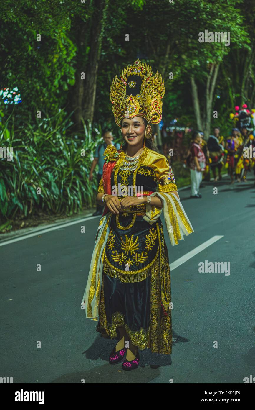 Balikpapan, Indonésie - 5 juin 2024. La jeune fille marche dans la rue lors d'un défilé pendant le défilé du festival culturel indonésien. Banque D'Images