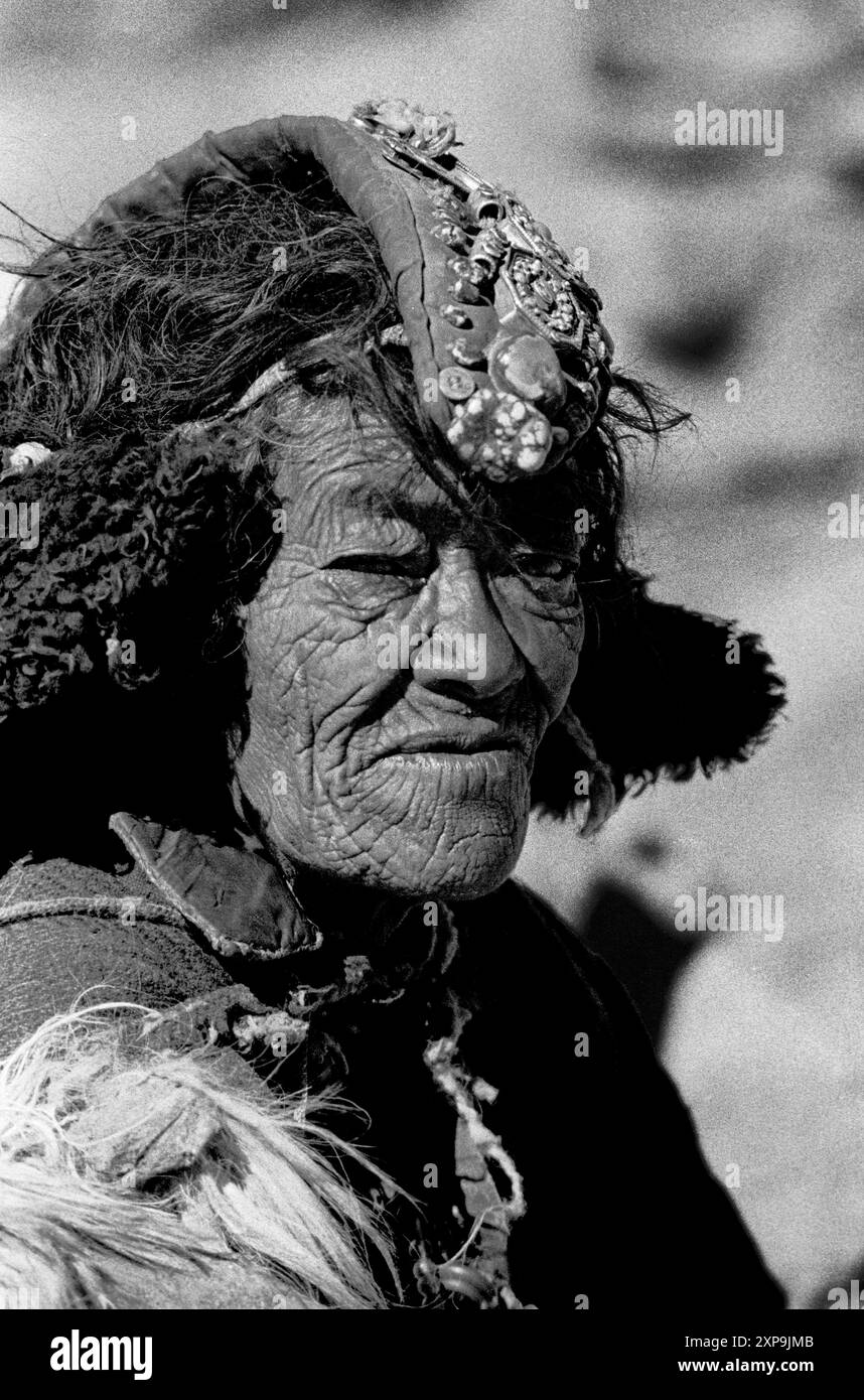 Une vieille femme porte un perak plein de pierres précieuses dans le cadre de sa robe traditionnelle au Ladakh, Inde - 1988 Banque D'Images