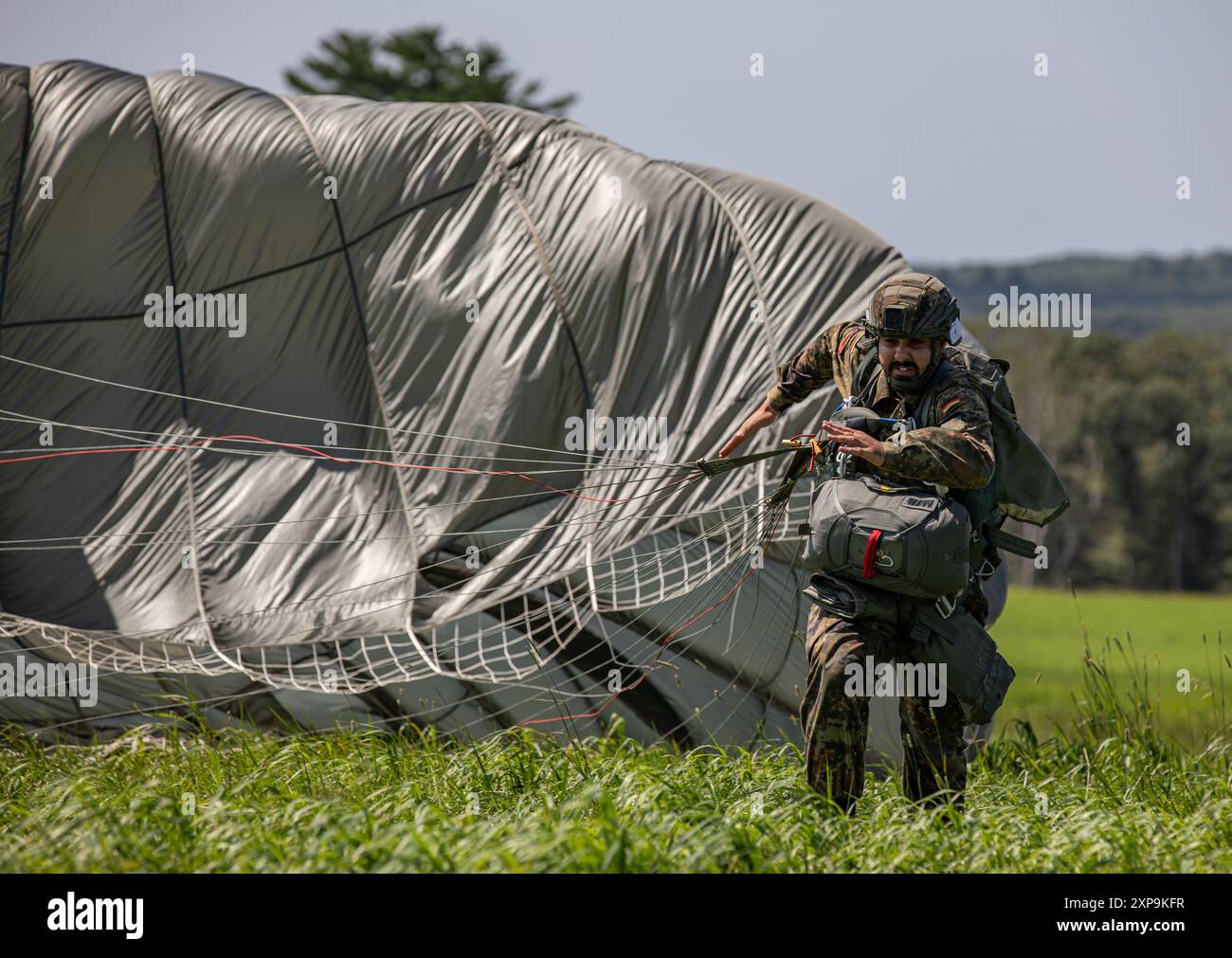 Un parachutiste allemand traîne son MC-6 Parachute alors qu'il court vers le X lors du Leapfest 2024 à Glenrock Drop zone, Exeter, Rhode Island, le 3 août 2024. Leapfest est le plus grand événement international de formation de parachute de ligne statique et compétition organisé par le 56th Troop Command, Rhode Island Army National Guard pour promouvoir la formation technique de haut niveau et l'esprit de corps au sein de la communauté aéroportée internationale. (Photo de la réserve de l'armée américaine par le Sgt. 1re classe Austin Berner) Banque D'Images