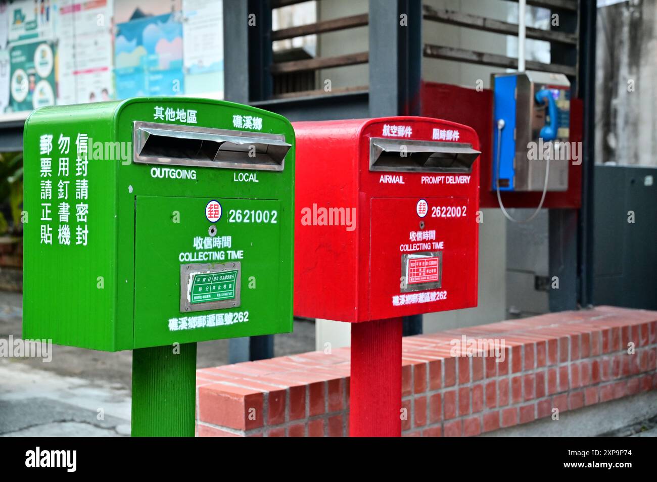 Taiwan - 03 août 2024 : capturez le contraste nostalgique d'une boîte aux lettres traditionnelle et d'une cabine téléphonique. Banque D'Images