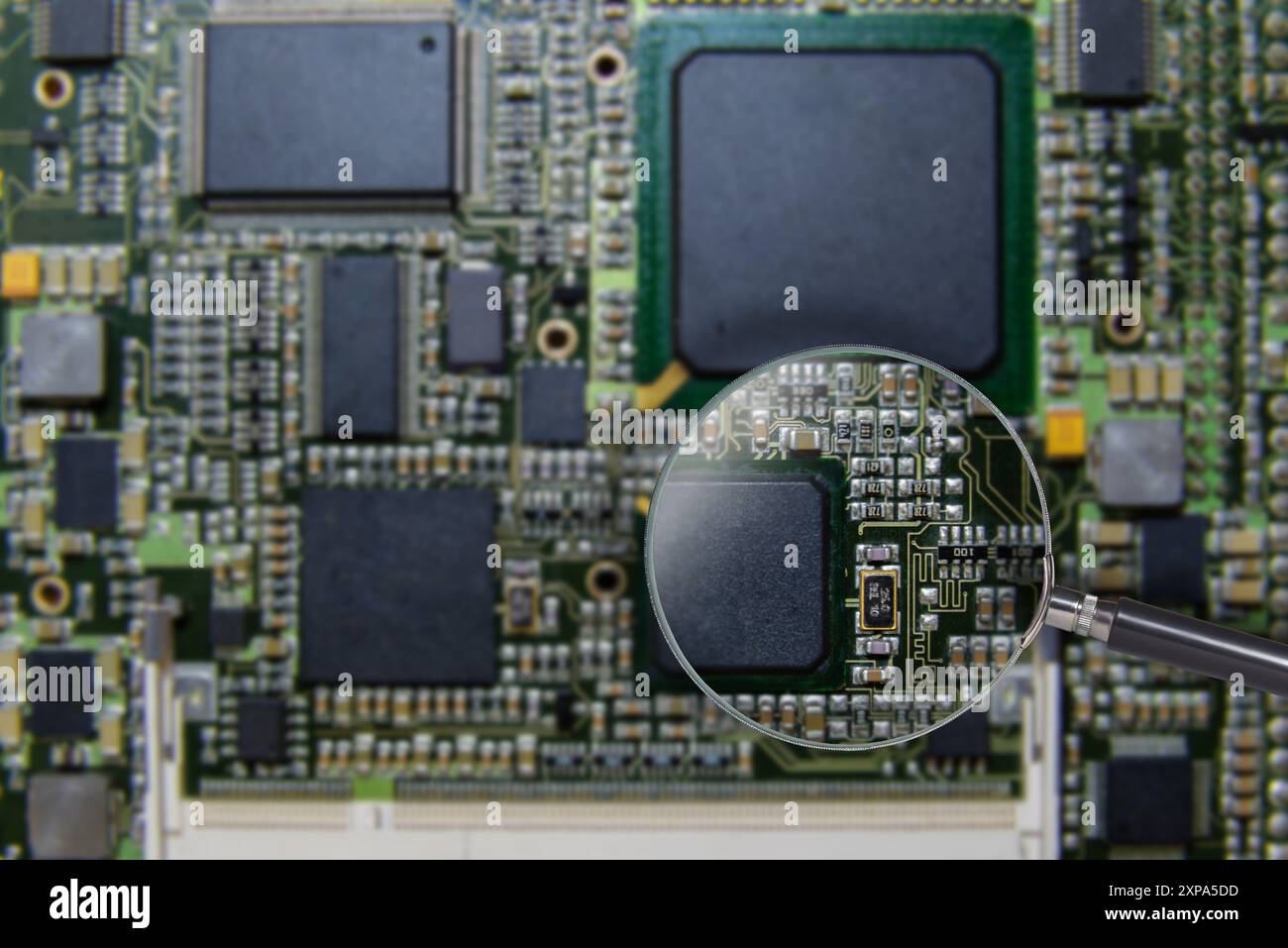Vue détaillée d'une carte mère d'ordinateur avec une loupe mettant en évidence les composants du circuit, mettant en valeur la technologie et la précision de l'ingénierie. Banque D'Images