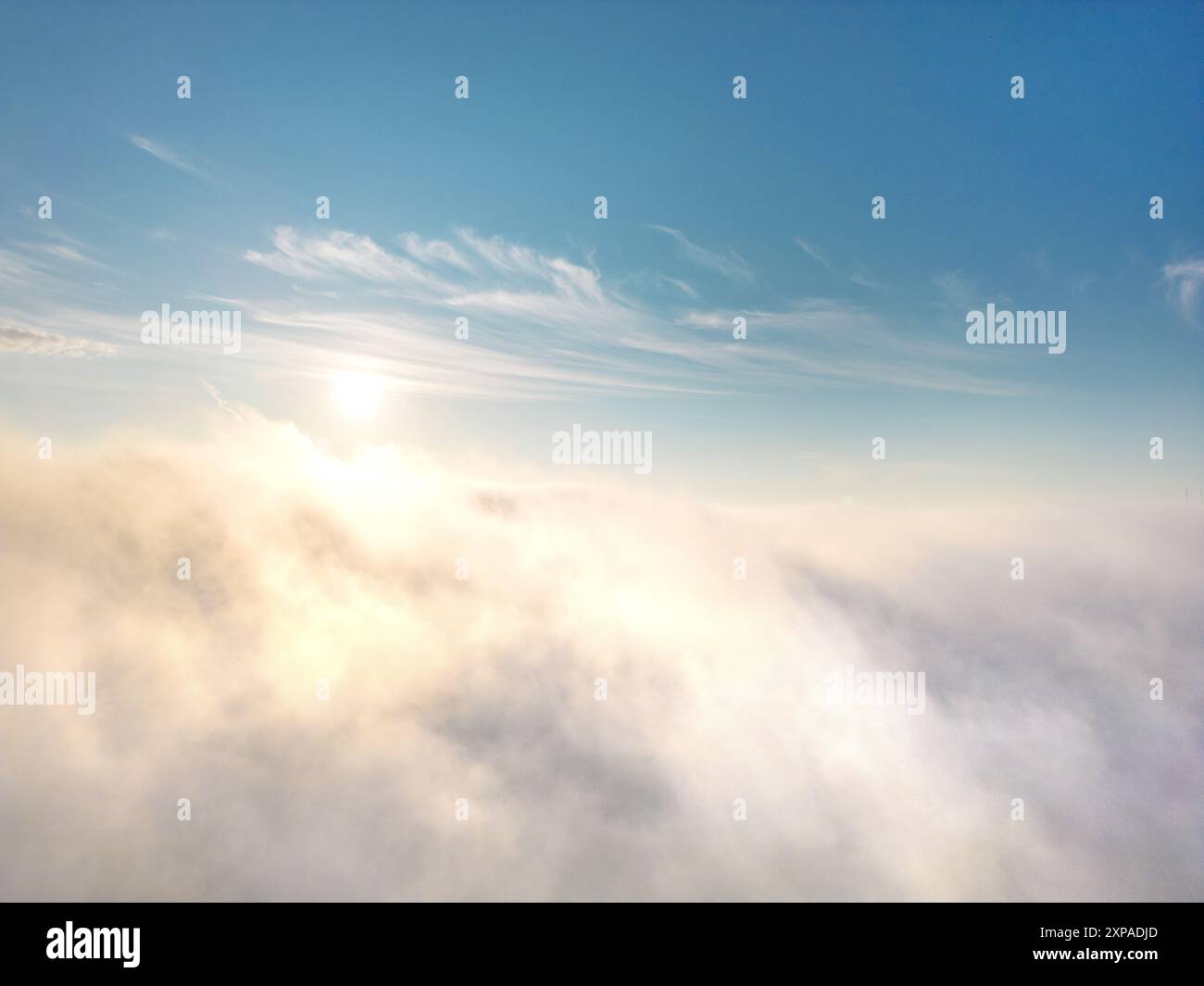 Vue d'en haut du brouillard ou des nuages avec un ciel bleu clair et le soleil levant en arrière-plan Banque D'Images