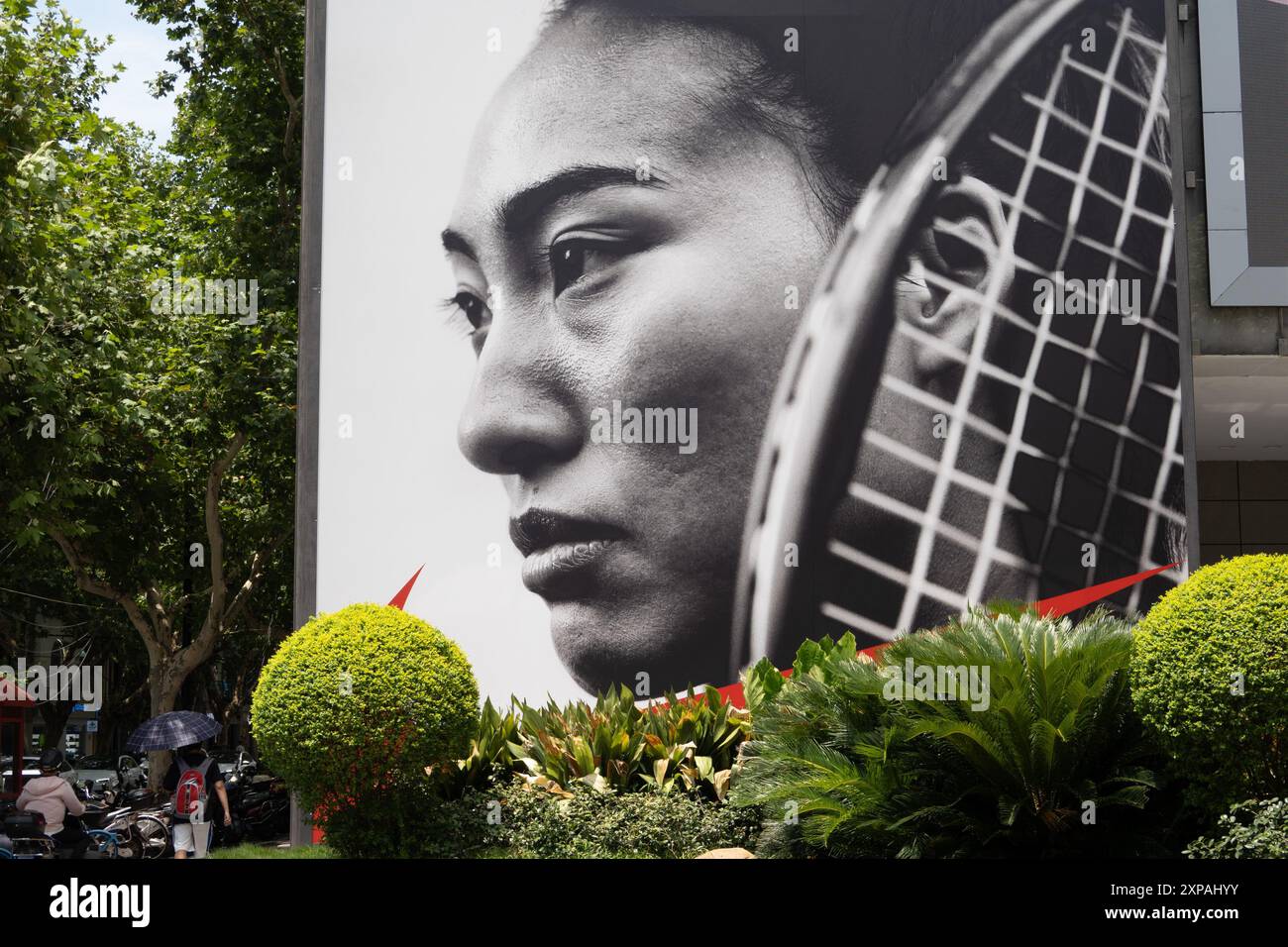 SHANGHAI, CHINE - 27 JUILLET 2024 - Une grande affiche de la championne olympique de tennis féminine Zheng Qinwen est vue sur un mur à l'extérieur d'un centre commercial à Shanghai Banque D'Images