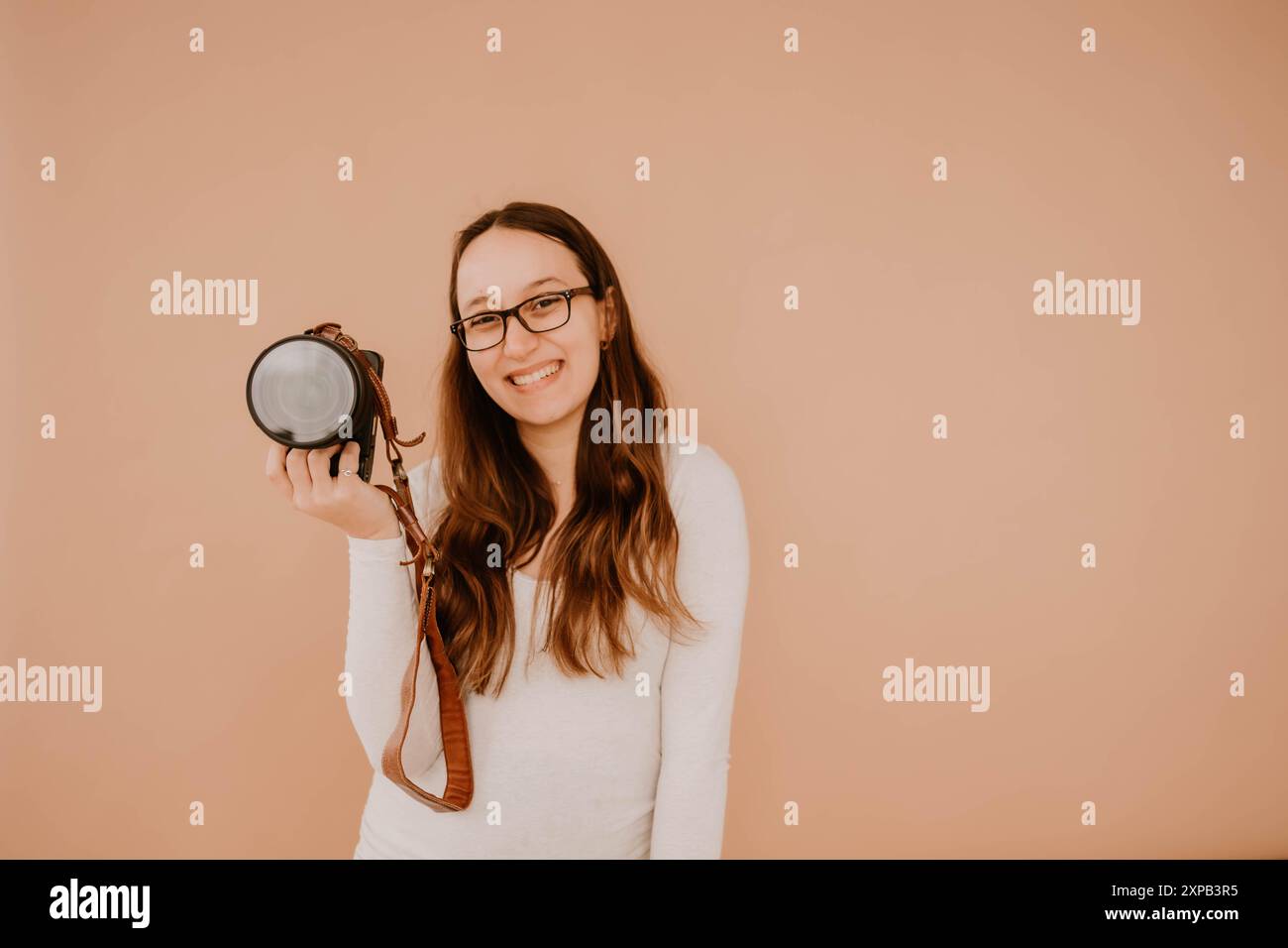 Photographe hispanique souriante tenant un appareil photo Banque D'Images