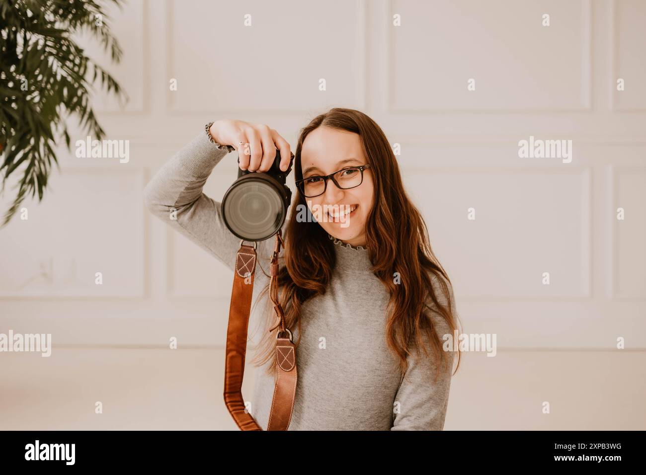 Souriant jeune photographe hispanique tenant un appareil photo Banque D'Images