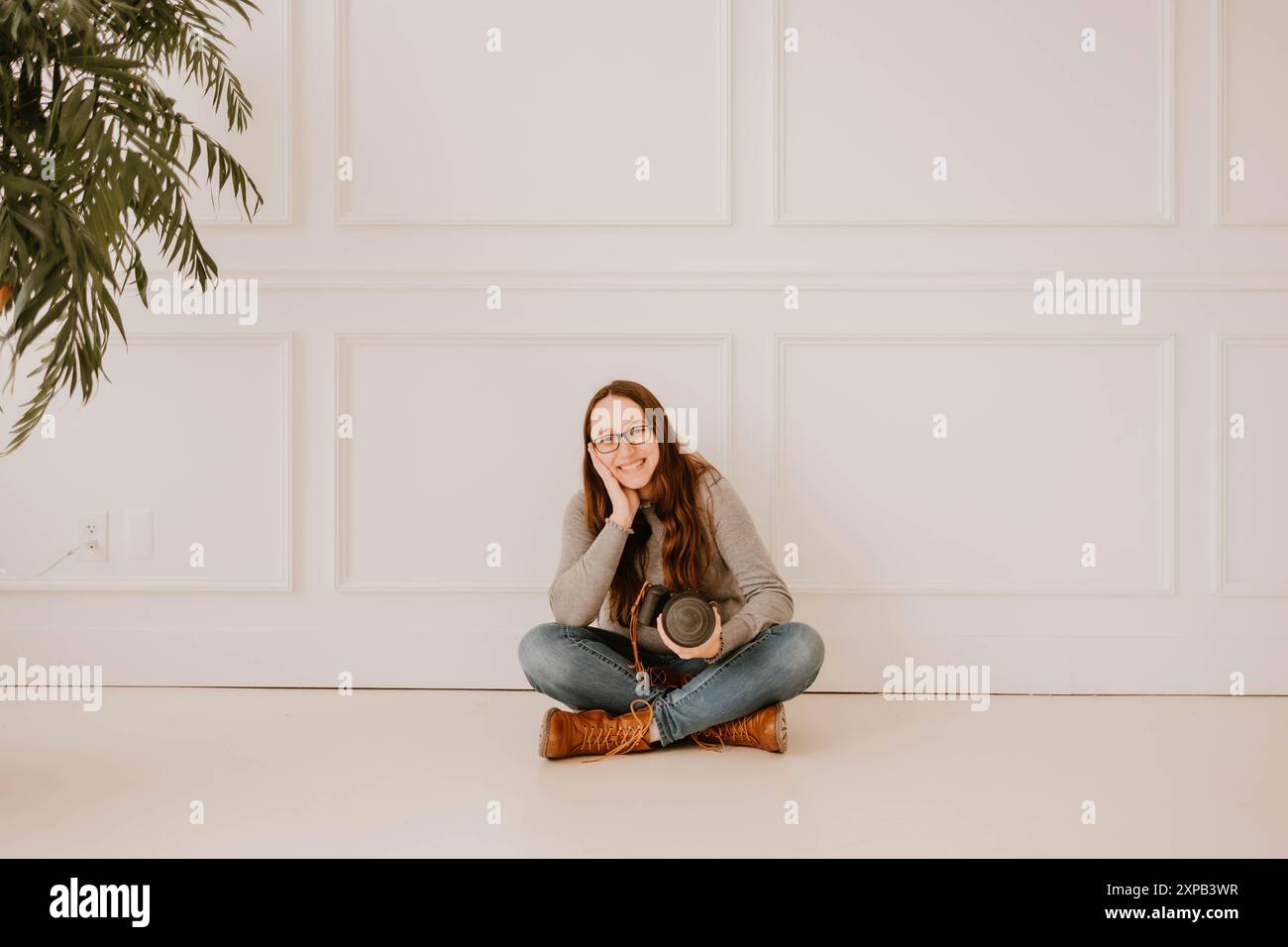 Photographe hispanique souriante tenant un appareil photo Banque D'Images