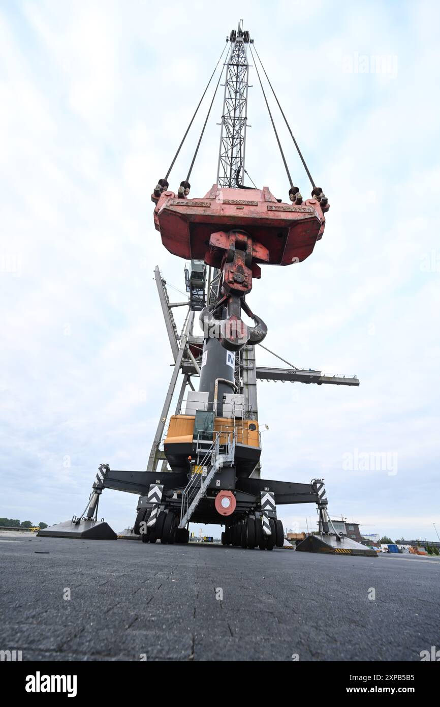 Frein, Allemagne. 05 août 2024. La grue portuaire mobile (LHM 550) d’une capacité de levage de 154 tonnes attend le chargement des locomotives électriques. Tout est encore au repos à Niedersachsenkai dans le port. Deux locomotives électriques échouées de Rail Cargo Carrier Germany GmbH (RCC) doivent être transportées par mer sur le bateau de navigation intérieure ELKA à l'aide de deux grues portuaires mobiles, probablement à 6 heures du matin le 7 août 2024. La route des locomotives a été coupée en raison d'un incendie de pont. Crédit : Lars Penning/dpa/Alamy Live News Banque D'Images