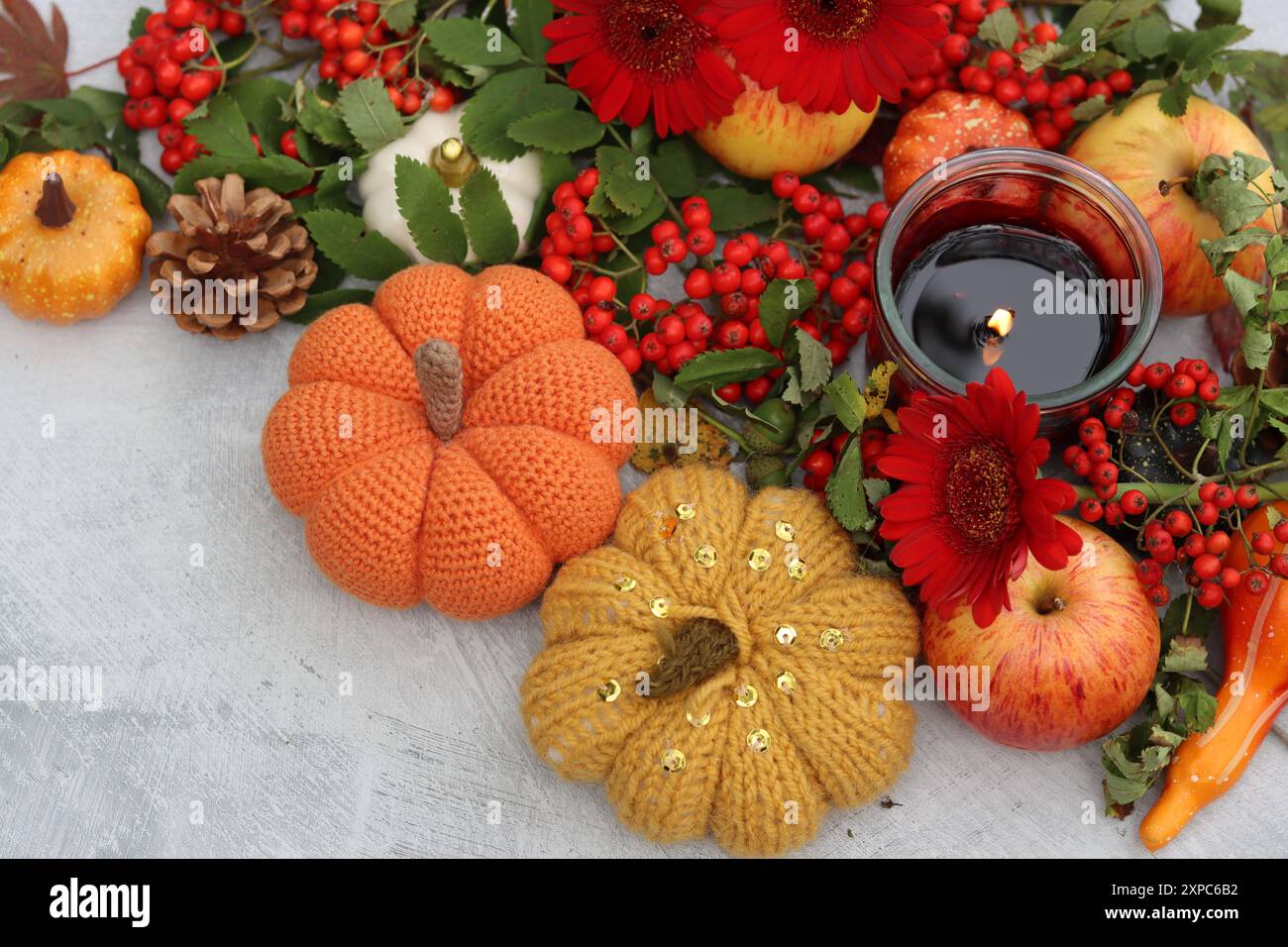 Nature morte d'automne chaude. Composition colorée avec des citrouilles décoratives, des baies de rowan, une bougie, des feuilles et des fleurs. Décorations de table gros plan photo. Banque D'Images