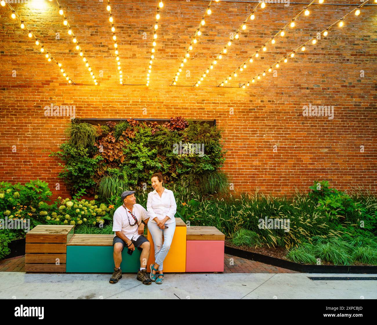 Un couple de personnes âgées profitant d'une soirée dans une ruelle pittoresque dans le quartier OTR de Cincinnati, Ohio. Banque D'Images