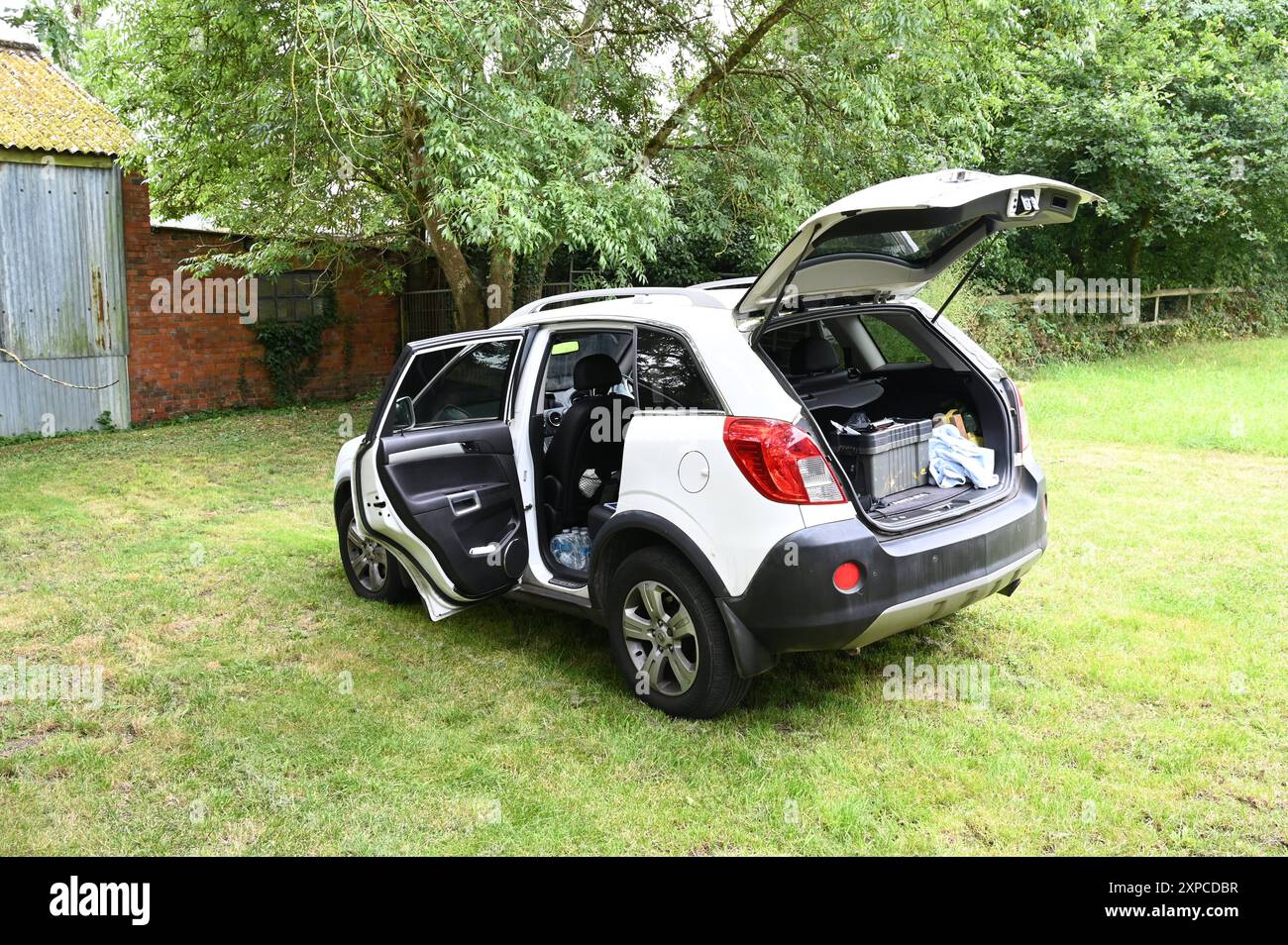 Vauxhall Antara 4x4 garé dans un champ avec la porte ouverte. Banque D'Images