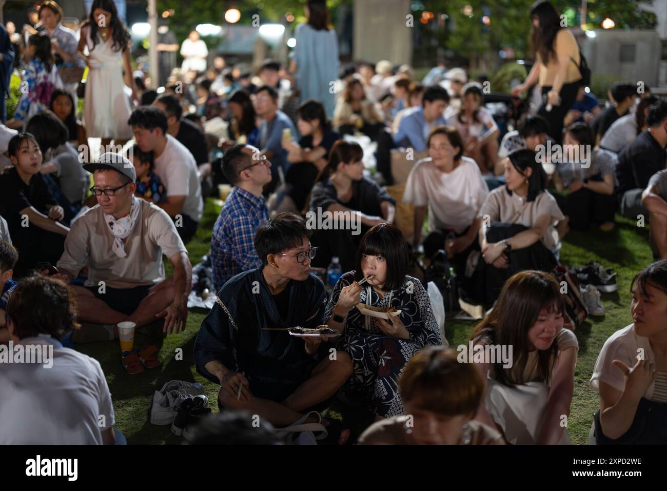 Tokyo, Japon. 03 août 2024. Les visiteurs du festival de danse de Tsukiji Honganji ont un picknick. Les festivals de danse bon odori ont lieu à travers le Japon tout l'été. Habituellement tenus dans des temples et des sanctuaires de différentes tailles, ils sont des événements axés sur la famille avec des spectacles de musique live, des stands de nourriture, des jeux amusants pour les enfants et de la danse pour tous. Les gens de tous âges se déguisent en vêtements traditionnels Yukata et célèbrent l'été ensemble. (Photo de Stanislav Kogiku/SOPA images/Sipa USA) crédit : Sipa USA/Alamy Live News Banque D'Images