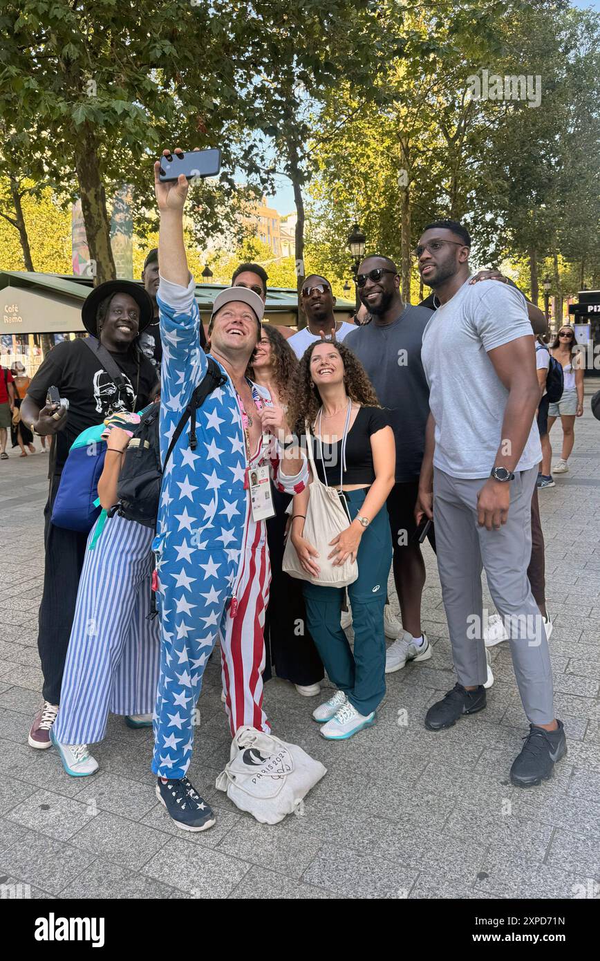 Paris, FR. 5 août 2024. Luol Deng et les membres de l'équipe olympique masculine sud-soudanaise de basket-ball s'arrêtent pour prendre une photo avec l'Instagrammer Brent Folan sur les champs-lyses lors des Jeux olympiques d'été de 2024 à Paris, France, le 5 août 2024. Crédit : Mpi34/Media Punch/Alamy Live News Banque D'Images