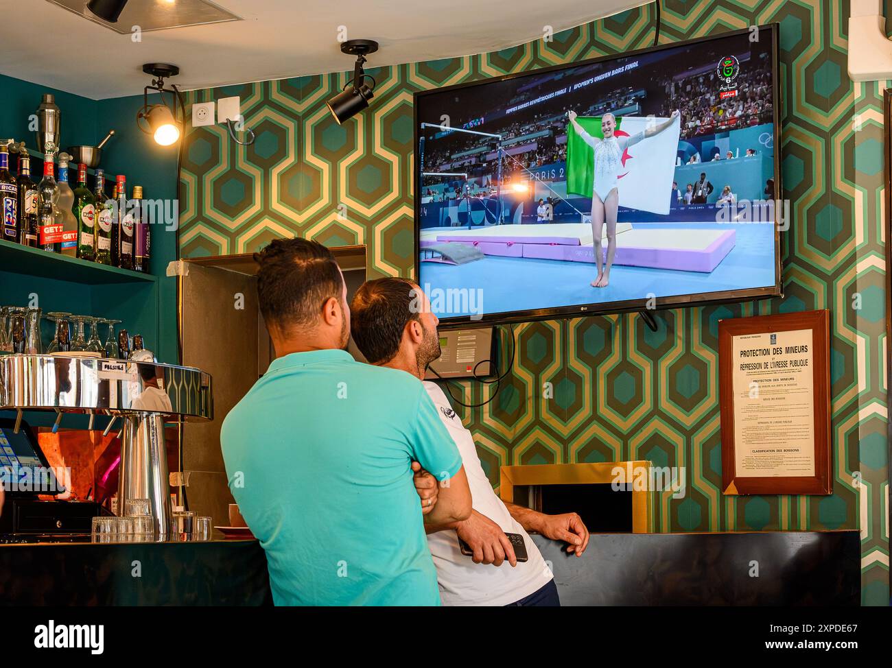 FRANCE. PARIS (75) (19ÈME ARRONDISSEMENT) 2024/08/04 : PENDANT LES JEUX OLYMPIQUES DE PARIS 2024, DANS LE QUARTIER DE STALINGRAD, LES CLIENTS D'UN CAFÉ REGARDENT LES JEUX OLYMPIQUES Banque D'Images