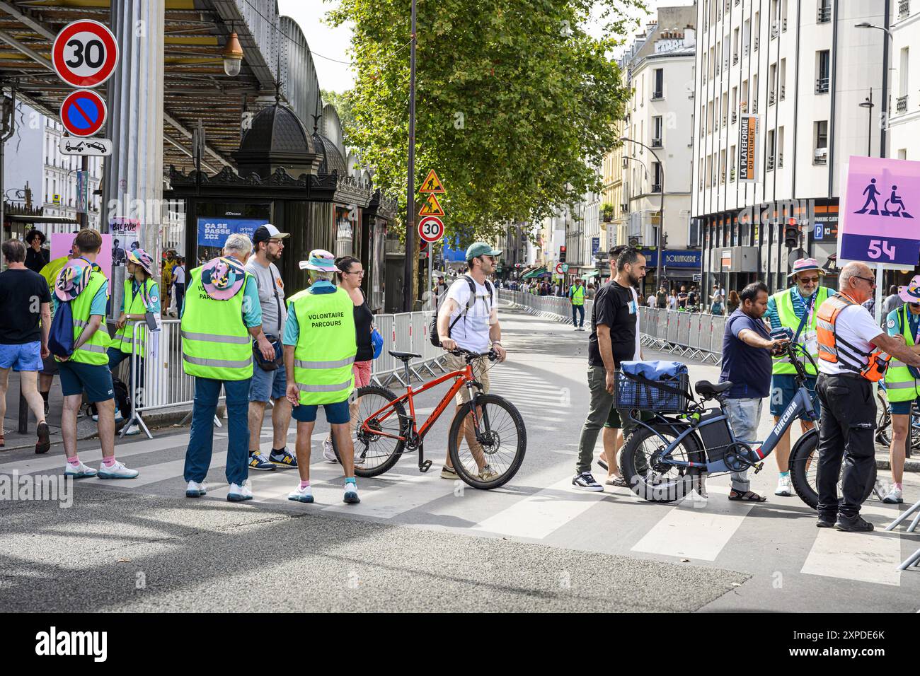 FRANCE. PARIS (75) (19ÈME ARRONDISSEMENT) PARIS JEUX OLYMPIQUES 2024. 2024/08/04 : PLACE STALINGRAD, LES BÉNÉVOLES ASSURENT LA SÉCURITÉ ET L'INFORMATION DU PUBLIC Banque D'Images