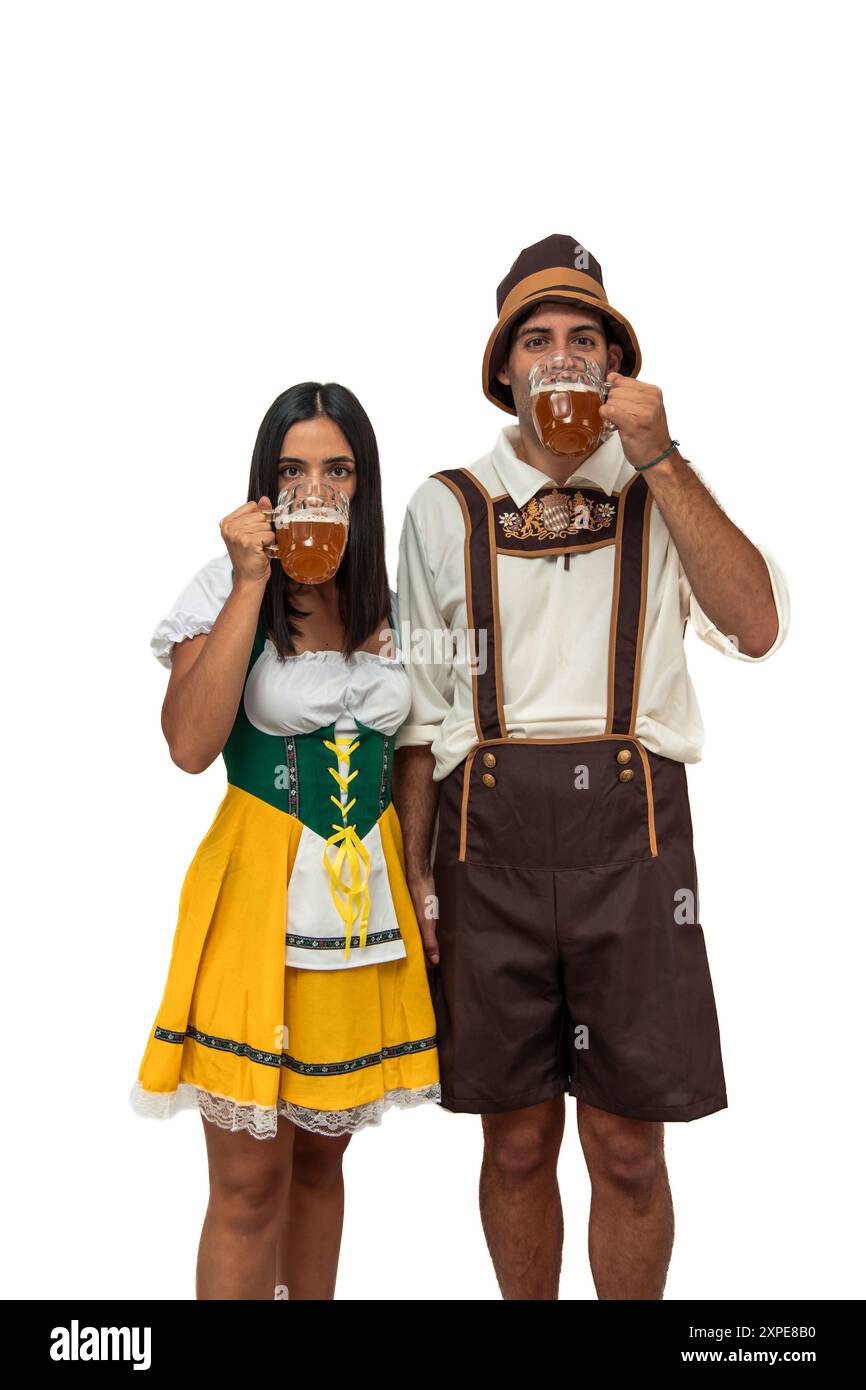 Vertical jeune couple bavarois vêtu de vêtements traditionnels Oktoberfest buvant de la bière. L'image capture l'atmosphère festive et culturelle tradi Banque D'Images