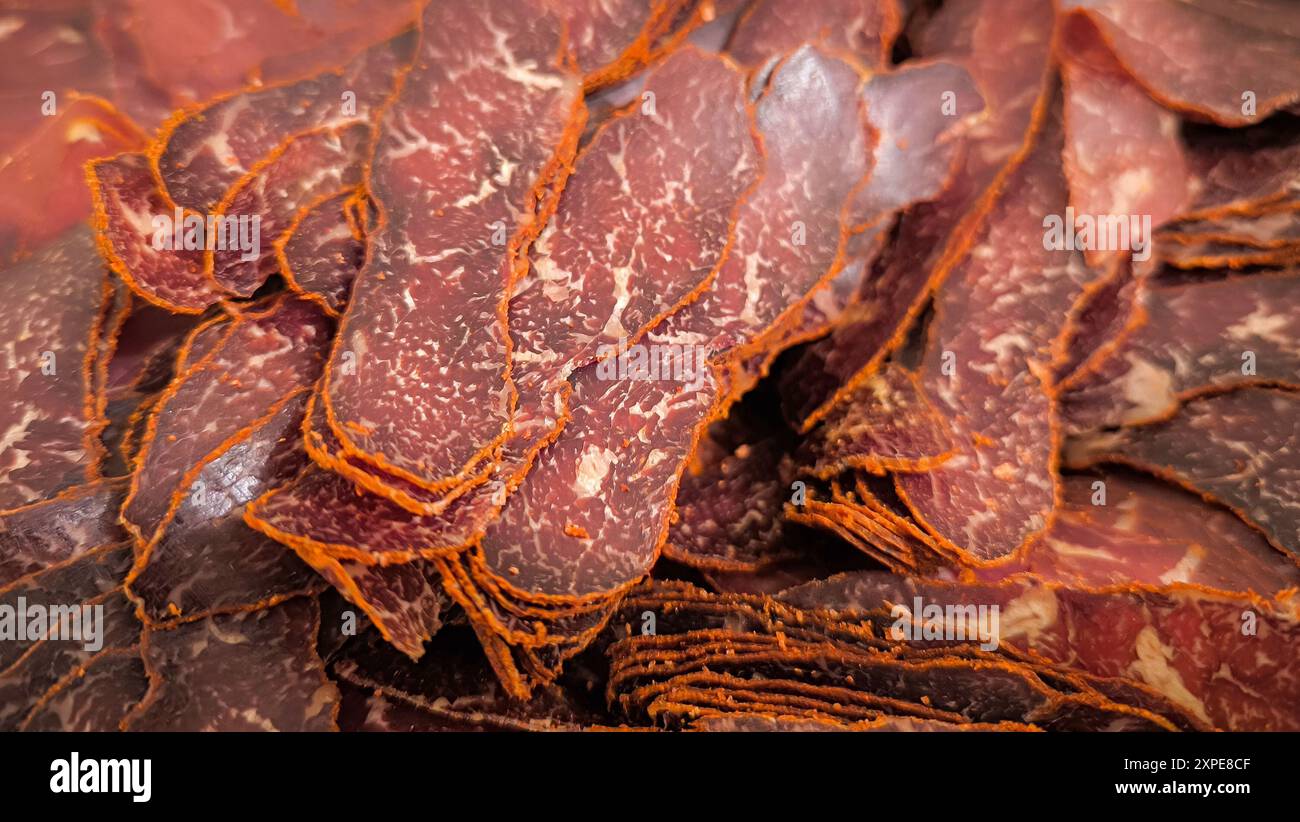 Tranches de viande séchée, mettant en valeur leurs motifs et textures complexes. Les couleurs naturelles du brun foncé au rouge se mélangent parfaitement avec les veines orange Banque D'Images