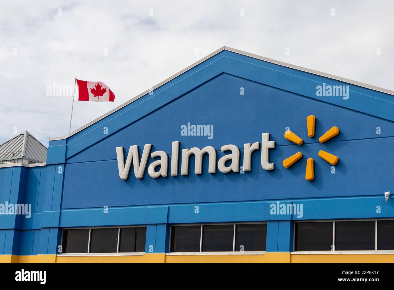 Kanata, Canada - 2 juin 2024 : immeuble de magasins de détail Walmart avec drapeau canadien Banque D'Images