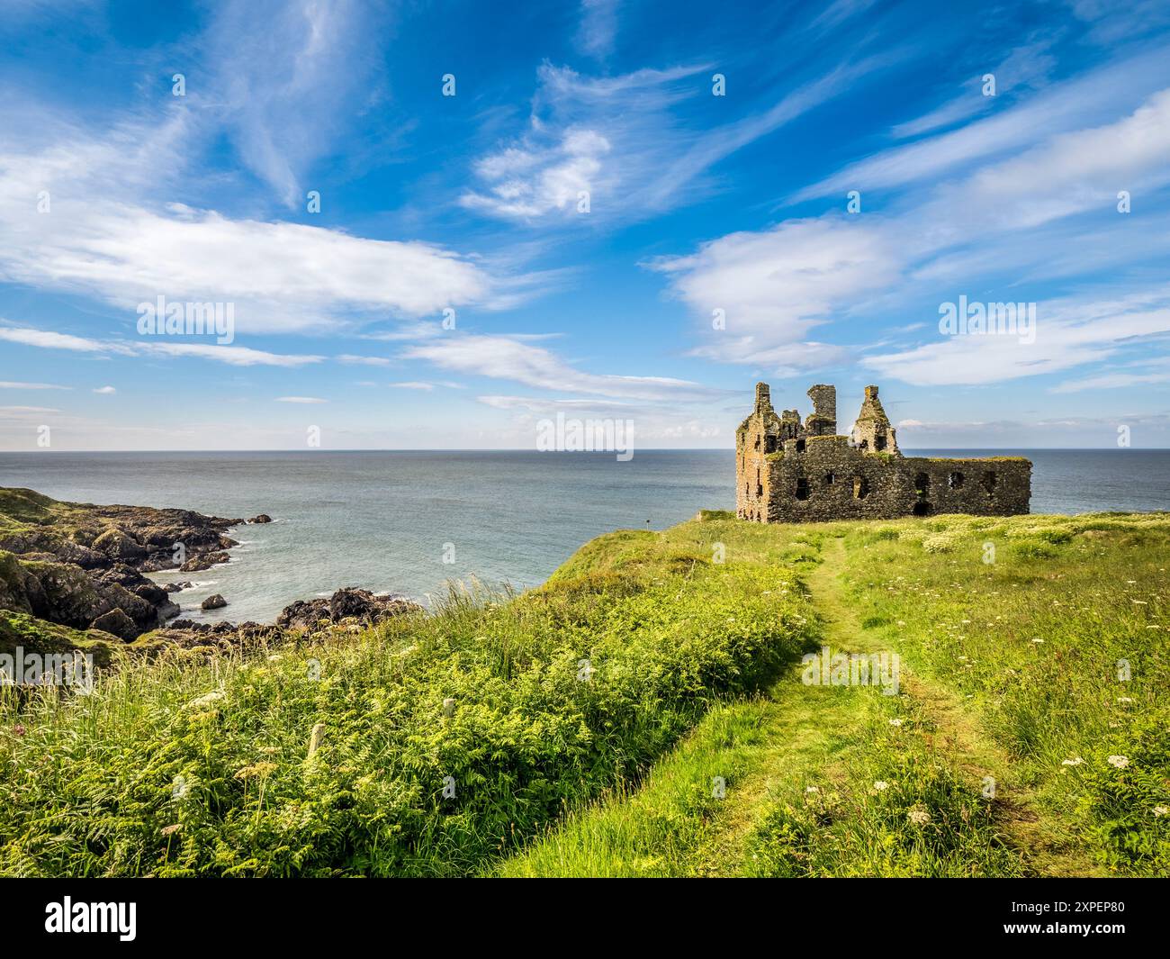 10 juin 2024 : Portpatrick, Dumfries et Galloway, Écosse - Dunskey Castle, une tour en ruine du XIIe siècle, debout sur le bord d'une falaise parmi Banque D'Images