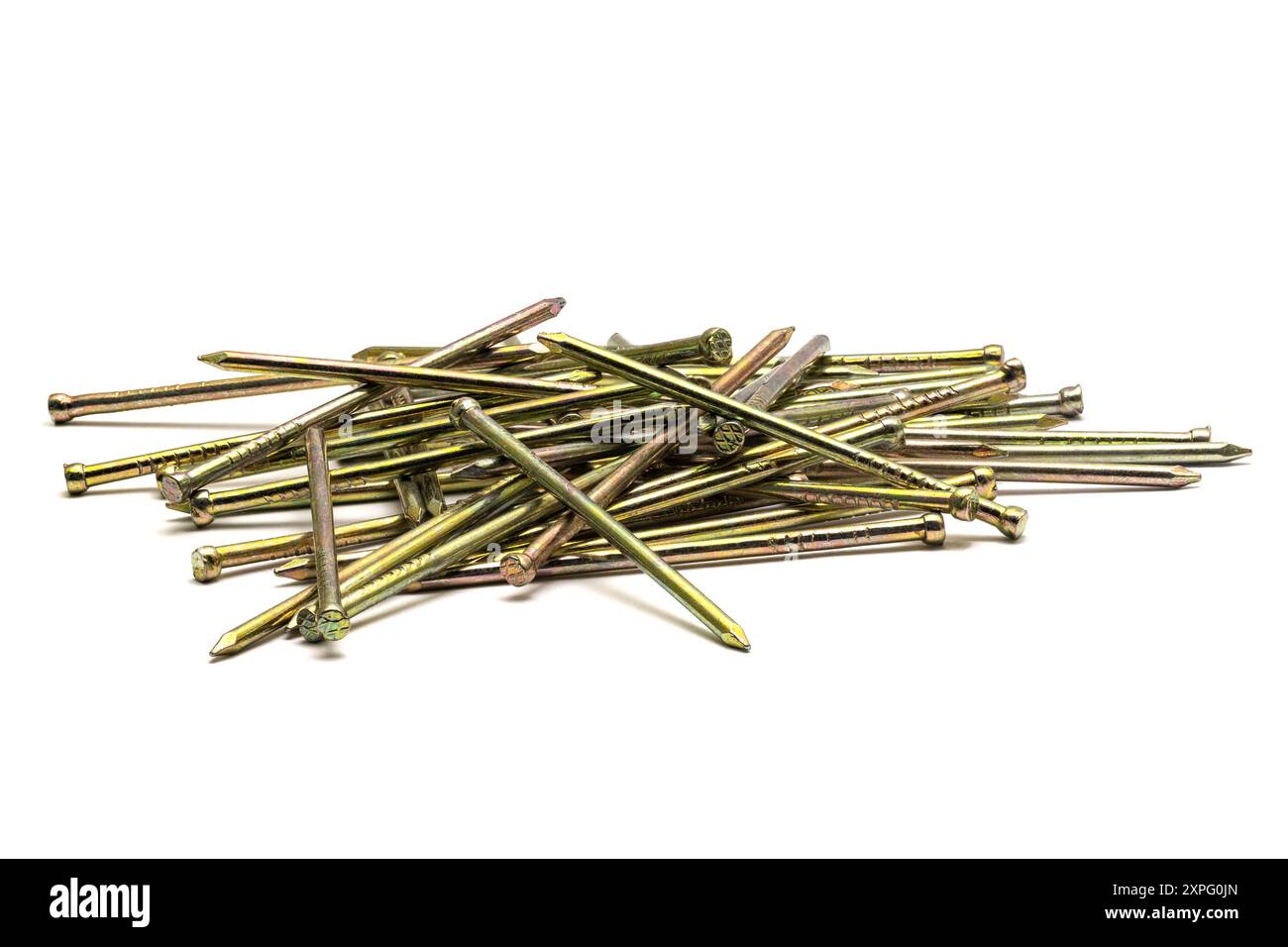Pile de clous métalliques minces pointus dorés dispersés sur fond blanc, gros plan macro Banque D'Images