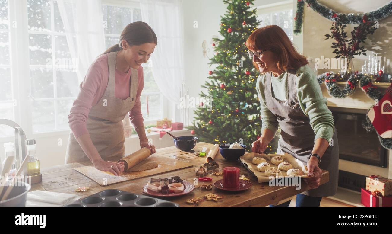 Portrait de mère adulte et fille préparant le dîner de Noël pour les invités. Belle femme et sa mère senior se liant tout en cuisinant, en parlant, en passant du temps ensemble pendant les vacances Banque D'Images