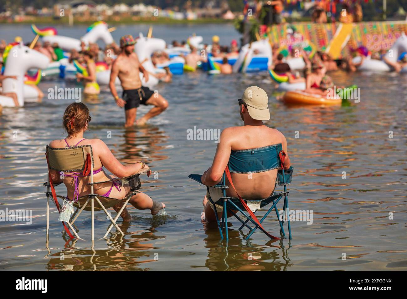 Roermond, Limbourg, pays-Bas. 2 août 2024. Les clients du camping Solar Weekend recherchent la fraîcheur au bord de l'eau. Solar Festival est l'un des festivals de plusieurs jours les plus créatifs des pays-Bas. En plus du programme musical diversifié composé de DJ, rappeurs et virages, il y a des bâtiments créatifs exposés, des jeux peuvent être joués et il y a du théâtre. Cette année, 800 créatifs et artistes ont participé à la construction du festival. Parce que c’est un festival de plusieurs jours (du 1er au 4 août), il y a aussi un camping sur le site autour du Maasplassen à Roermond. C’est la 17ème édition du festival, qui est expe Banque D'Images