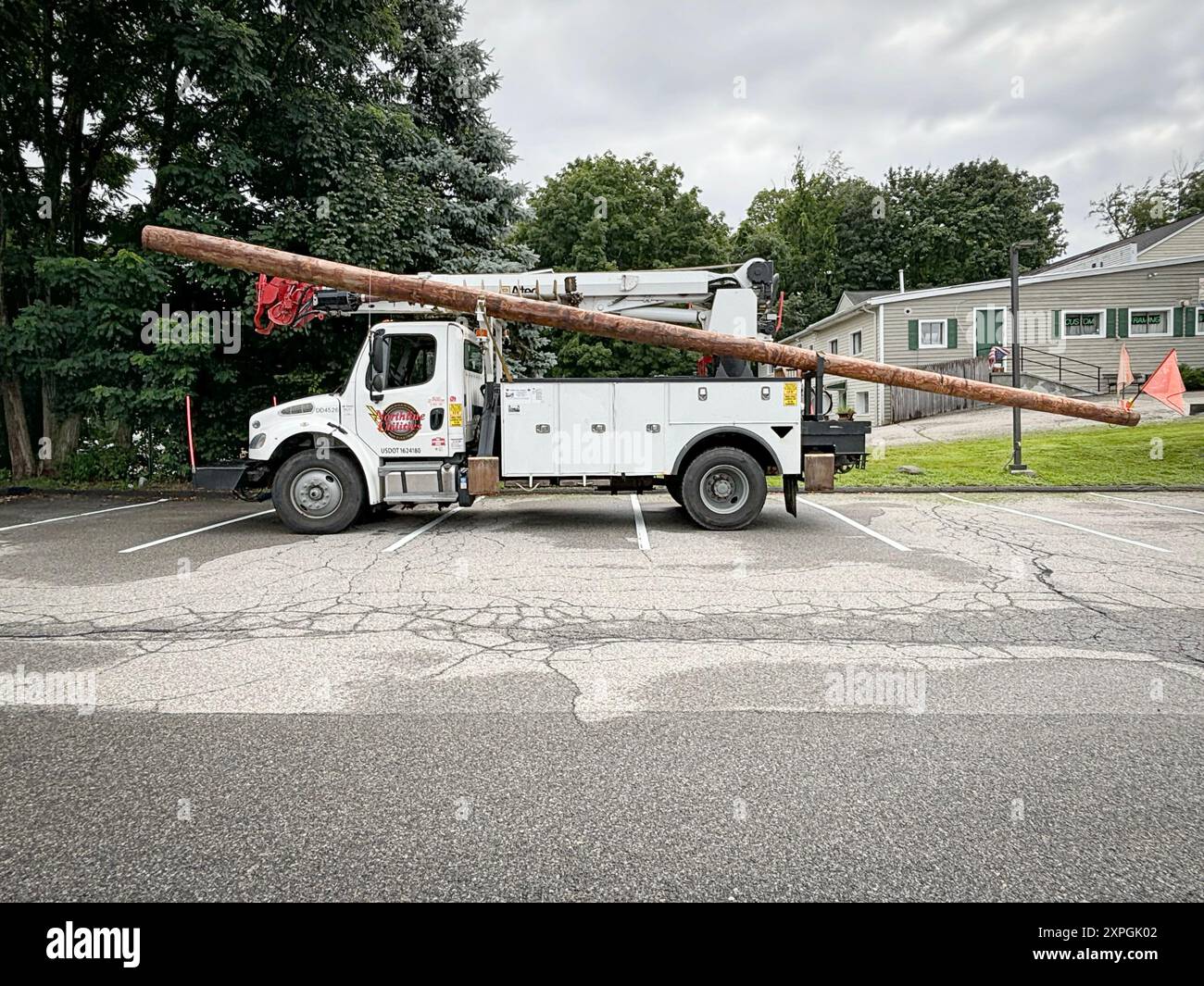 Un camion de Northline Utilities transportant un long poteau pour faire fonctionner les lignes électriques. Garé à Somers, Westchester, New York. Banque D'Images