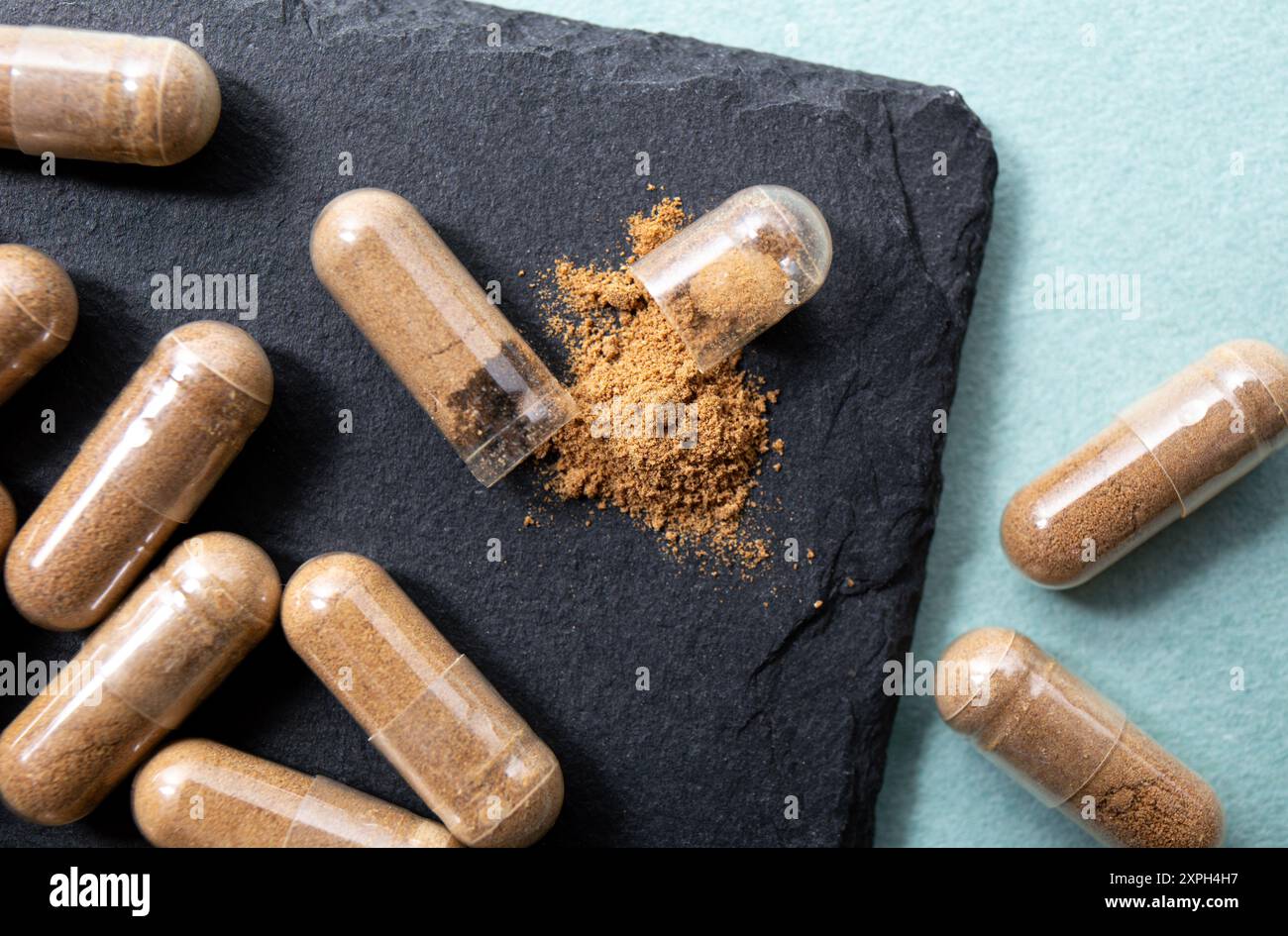 Withania somnifera connu sous le nom d'ashwagandha. Capsules de supplément de poudre de racine Ashwagandha sur fond noir. Banque D'Images