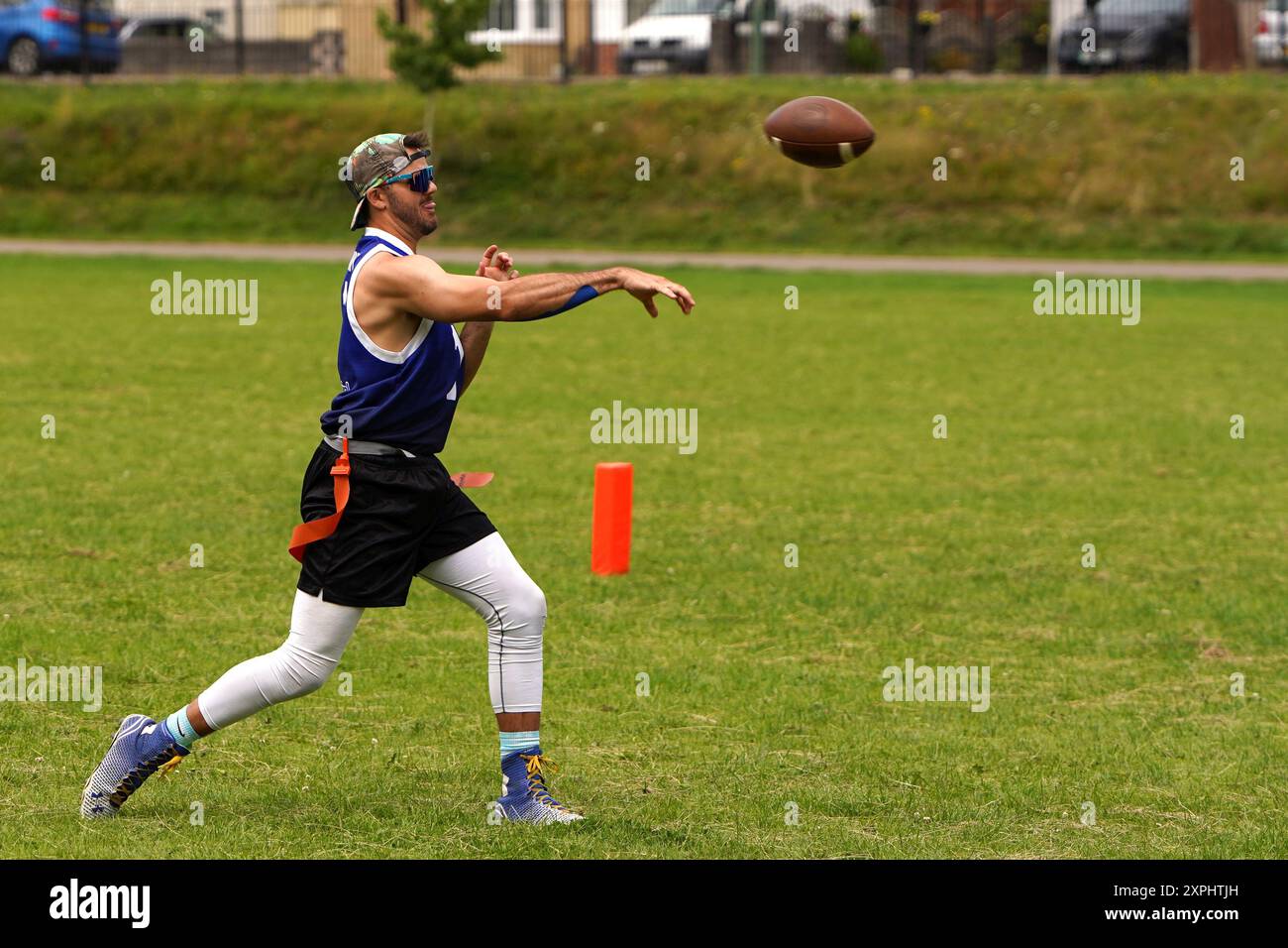 Un quart-arrière de football drapeau masculin lance le ballon Banque D'Images