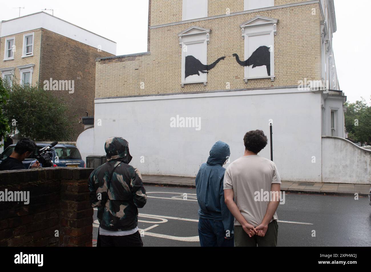 Londres, Royaume-Uni. 06 août 2024. Les gens passent devant une nouvelle murale de l'artiste de rue Banksy représentant deux éléphants dans des appuis de fenêtre qui a été dévoilée à Chesea. Crédit : Justin Ng/Alamy Live News Banque D'Images