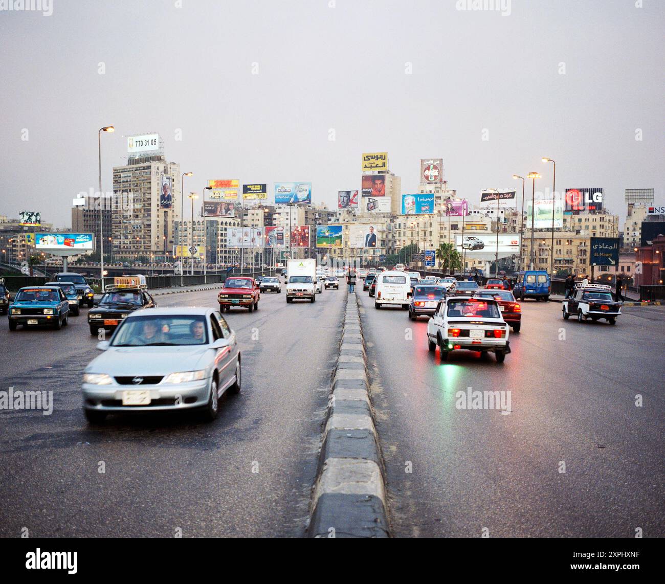 Une scène animée capturée à partir de la mi-octobre Pont au Caire, Egypte, 2006. Représente la circulation dense et les gratte-ciel animés de la ville avec de nombreuses publicités et panneaux d'affichage. Banque D'Images