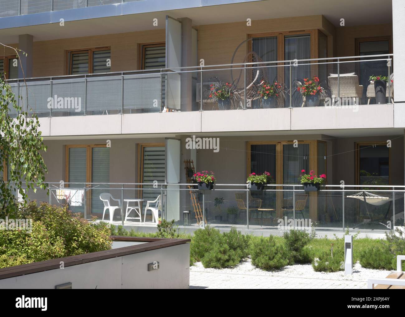 Beau balcon européen avec des fleurs et une chaise pivotante sur elle dans un immeuble Banque D'Images