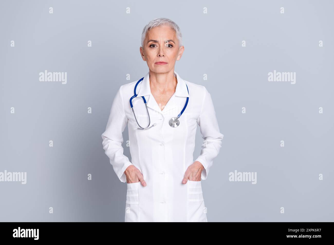 Photo de charmante femme médecin spécialiste qualifiée porter des diagnostics cliniques de robe blanche isolés sur fond de couleur grise Banque D'Images
